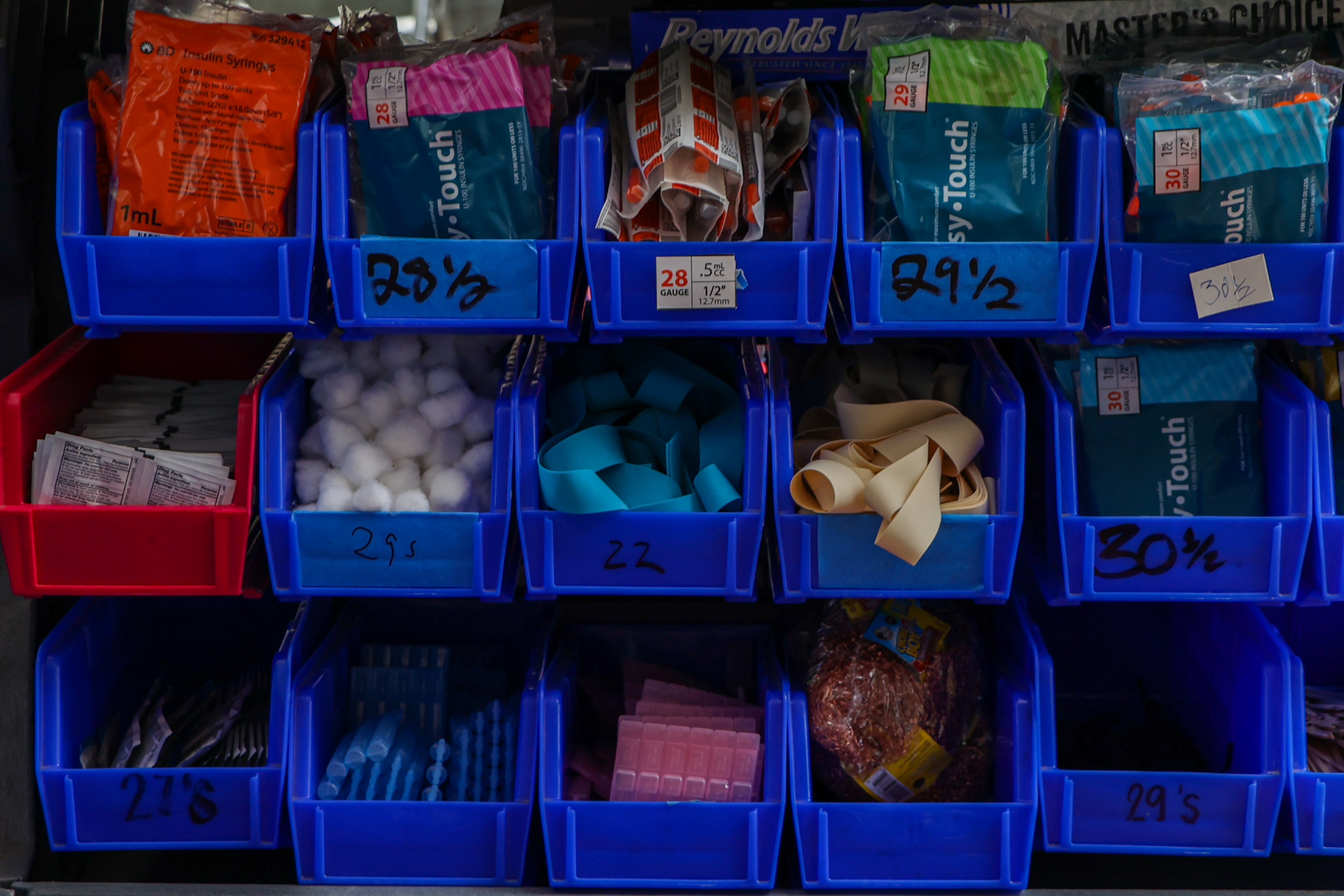 Blue storage bins with medical supplies, labeled with numbers and percentages.