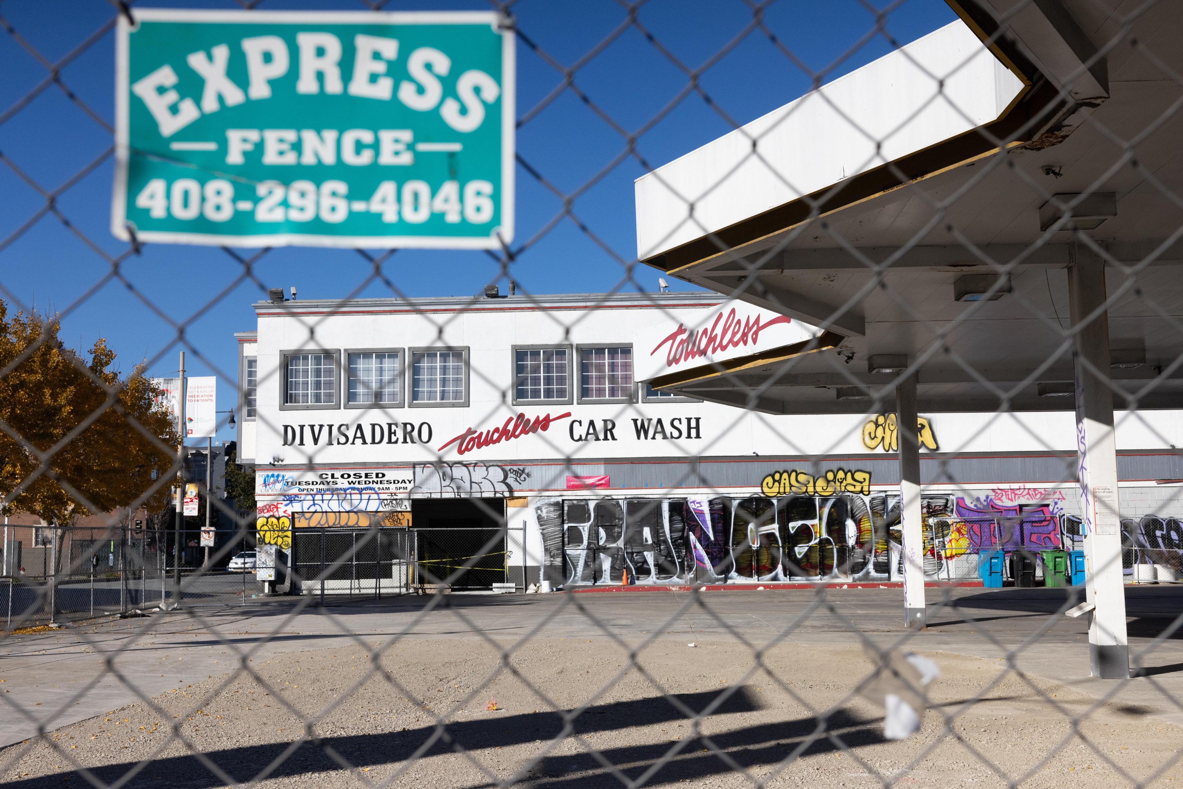 A fenced off gas station and car wash.