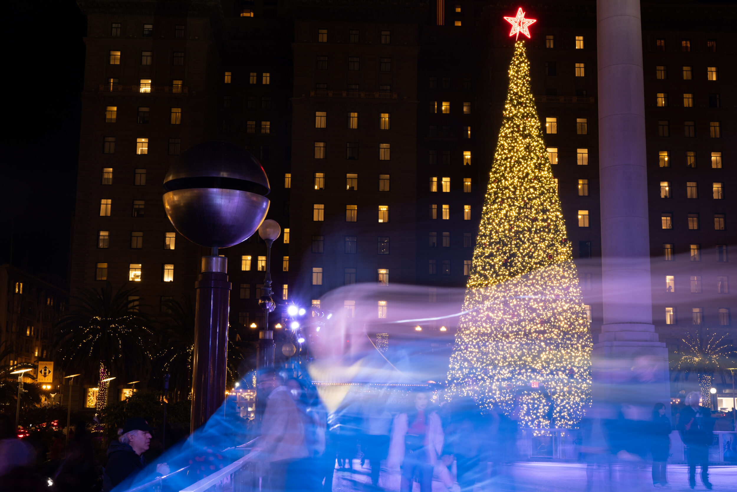 Union Square’s Christmas tree stands behind an ice skating rink filled with skaters. | Benjamin Fanjoy/The Standard