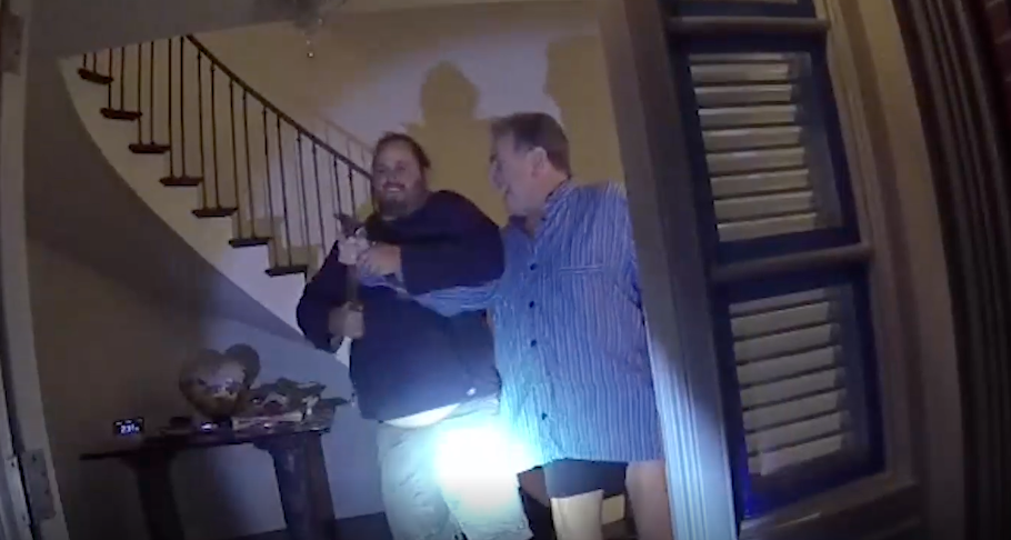 A still from policy body cam footage showing David Depape and Paul Pelosi struggle over a hammer in the threshold of a home.