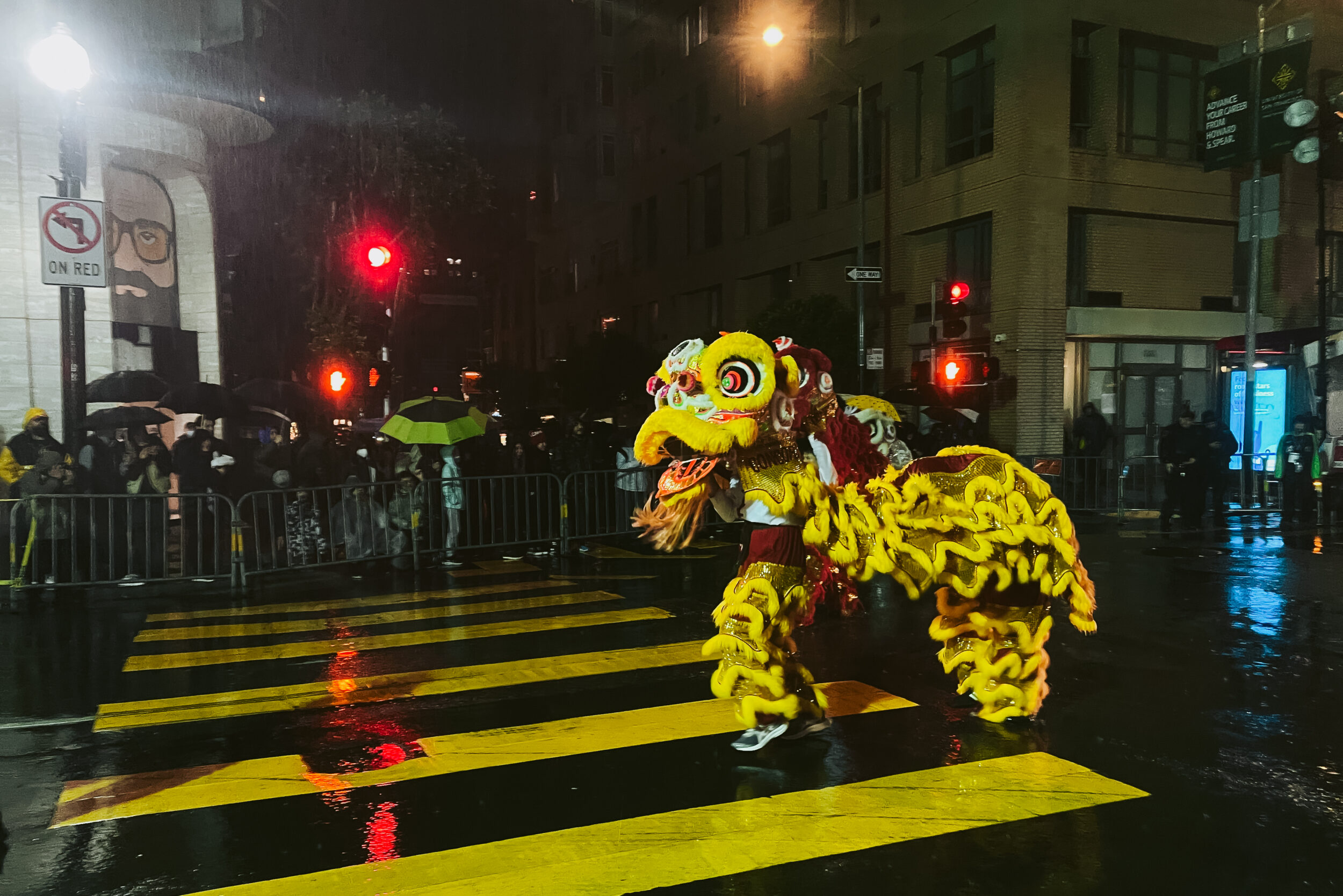 People wearing a dragon costume walk down the street during a nightime parade