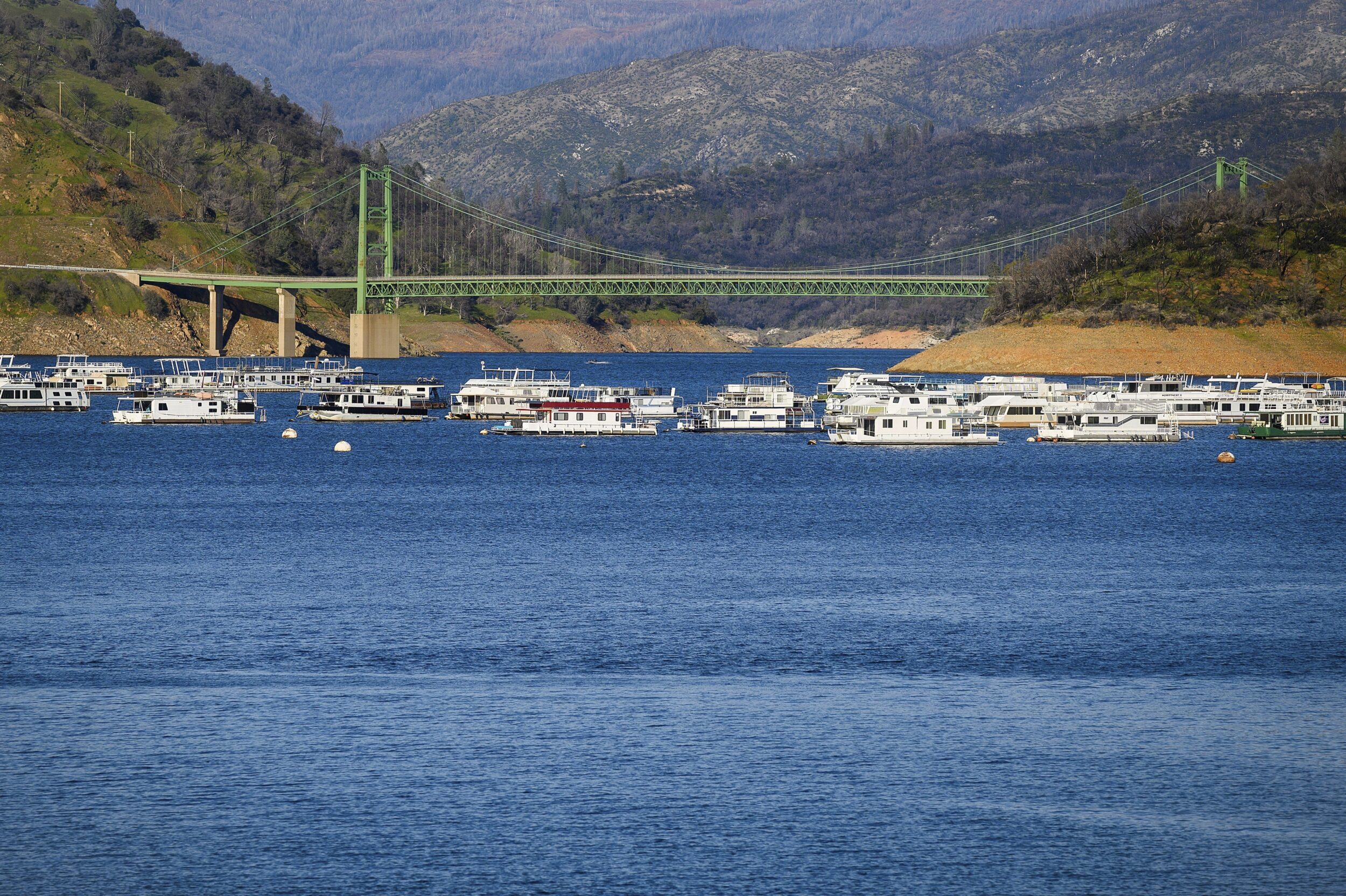 Houseboats moored on Oroville Lake with Bidwell Bridge in the background.