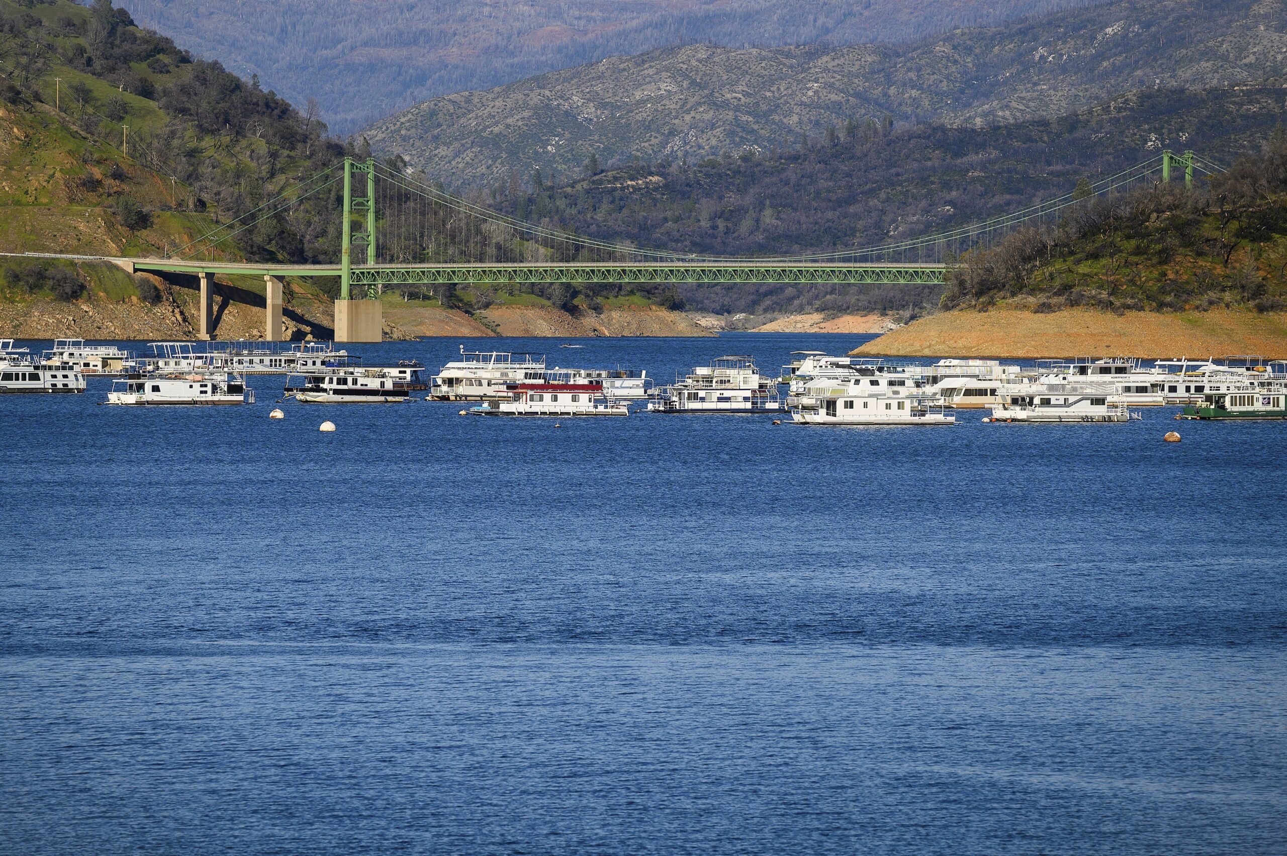 Houseboats moored on Oroville Lake with Bidwell Bridge in the background.