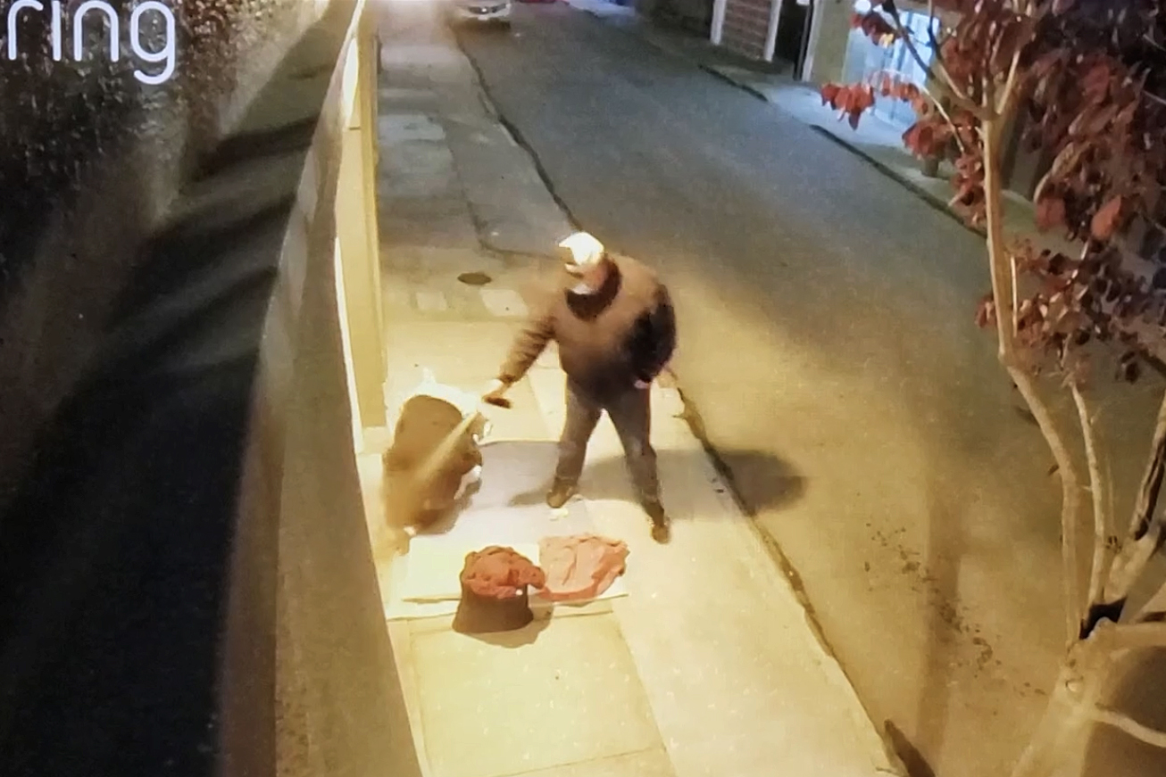 A person lying on the sidewalk is sprayed with bear mace.