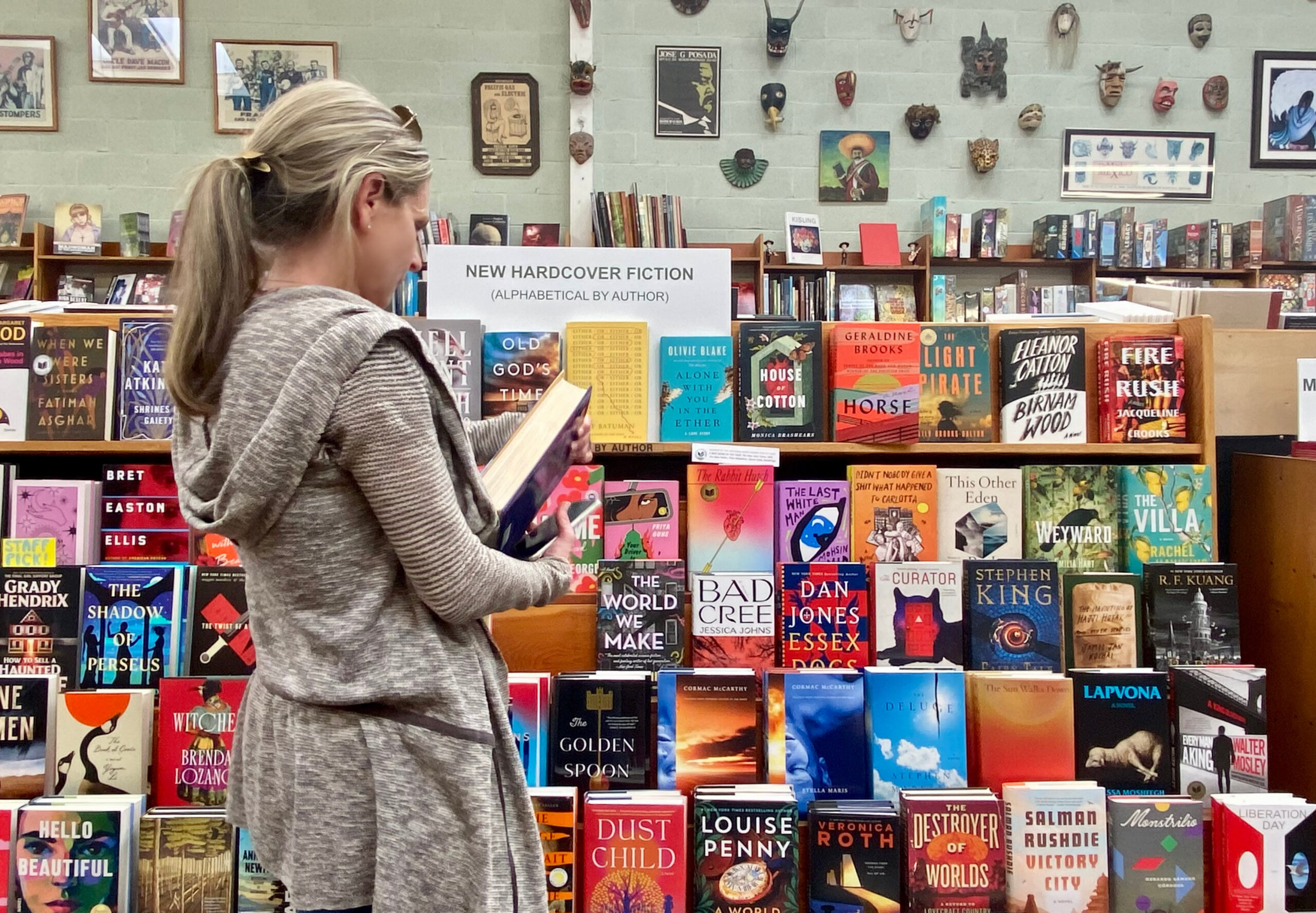 A woman browses for books in front of a book display.