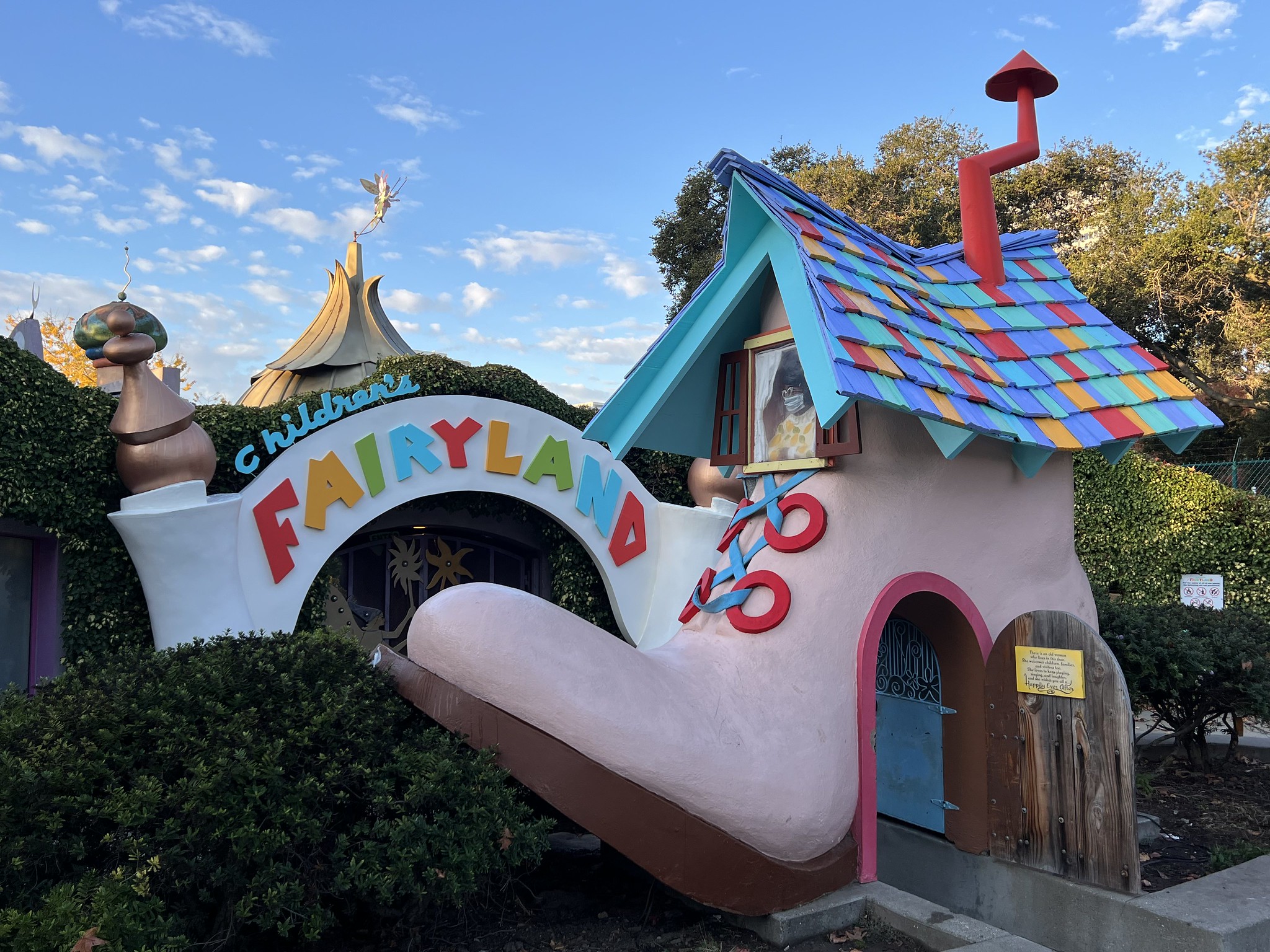 A giant pink shoe with a doorway and multicolor roof tiles says "Fairyland."