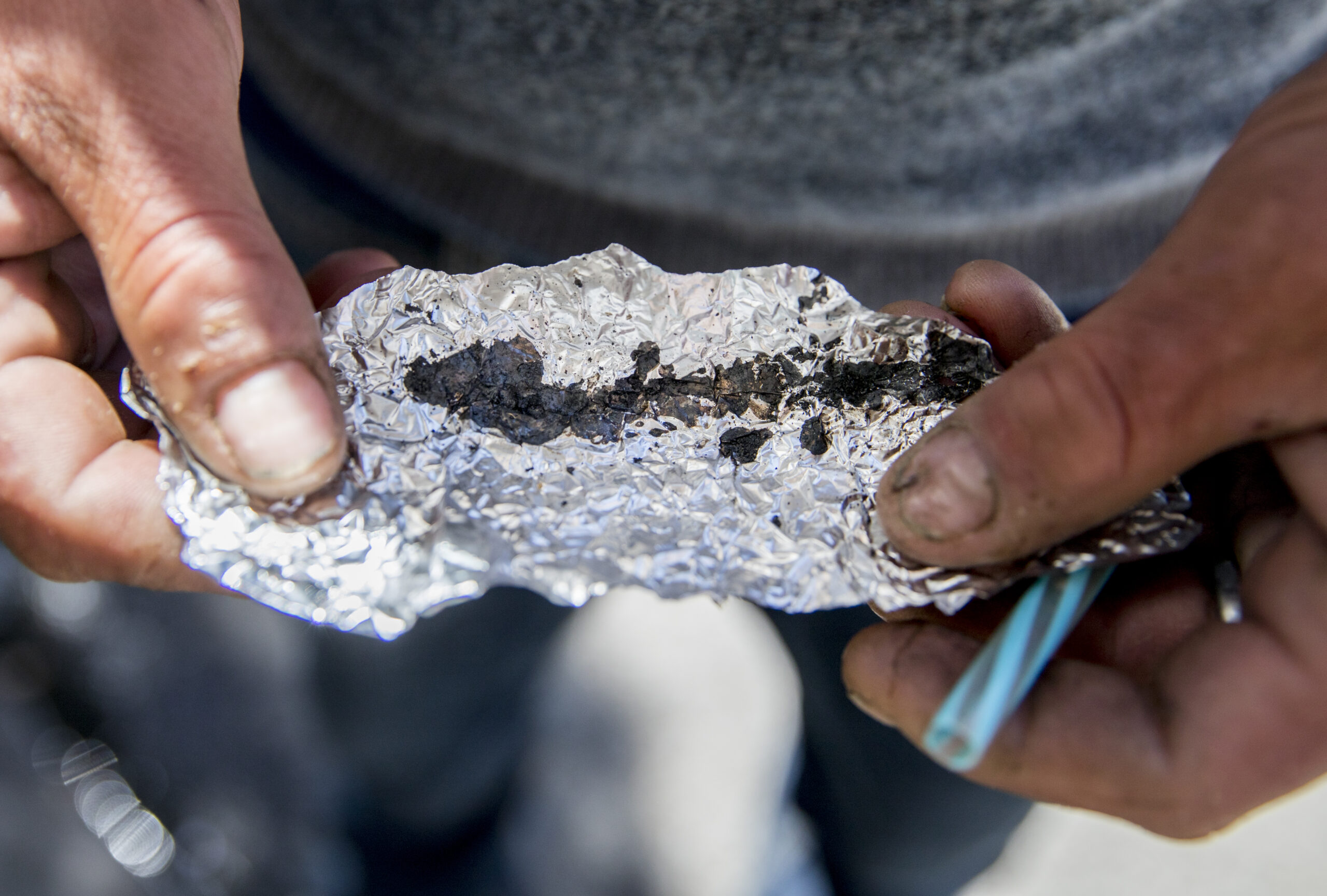 A person holding tin foil with drugs inside