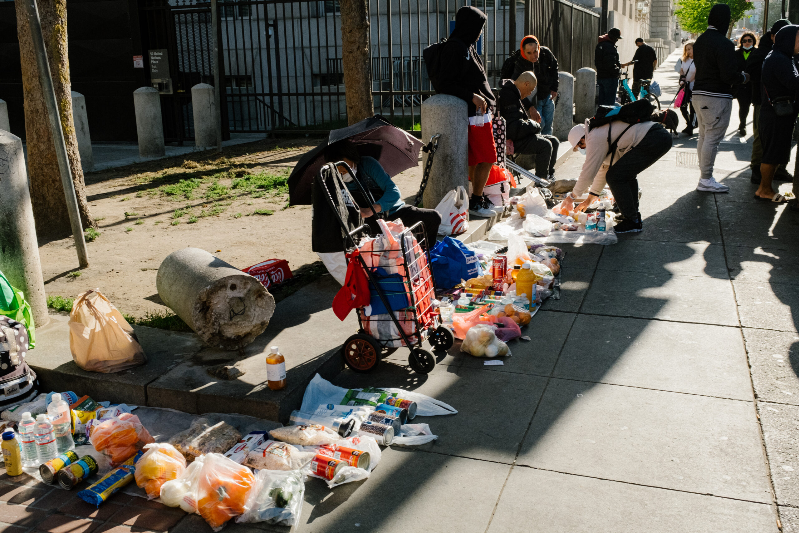 Vendors sell their wares on a sidewalk.