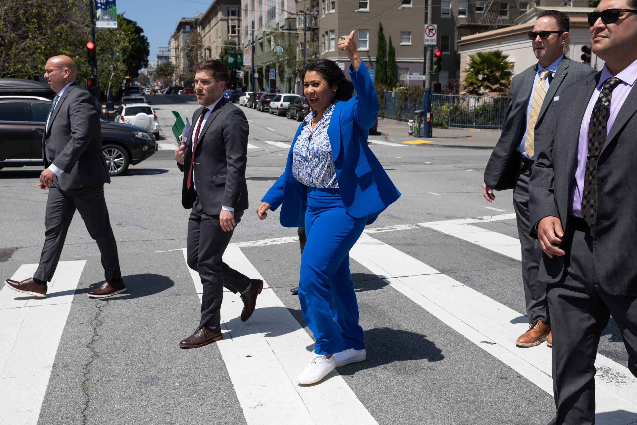 Mayor London Breed crosses a street with her colleagues.