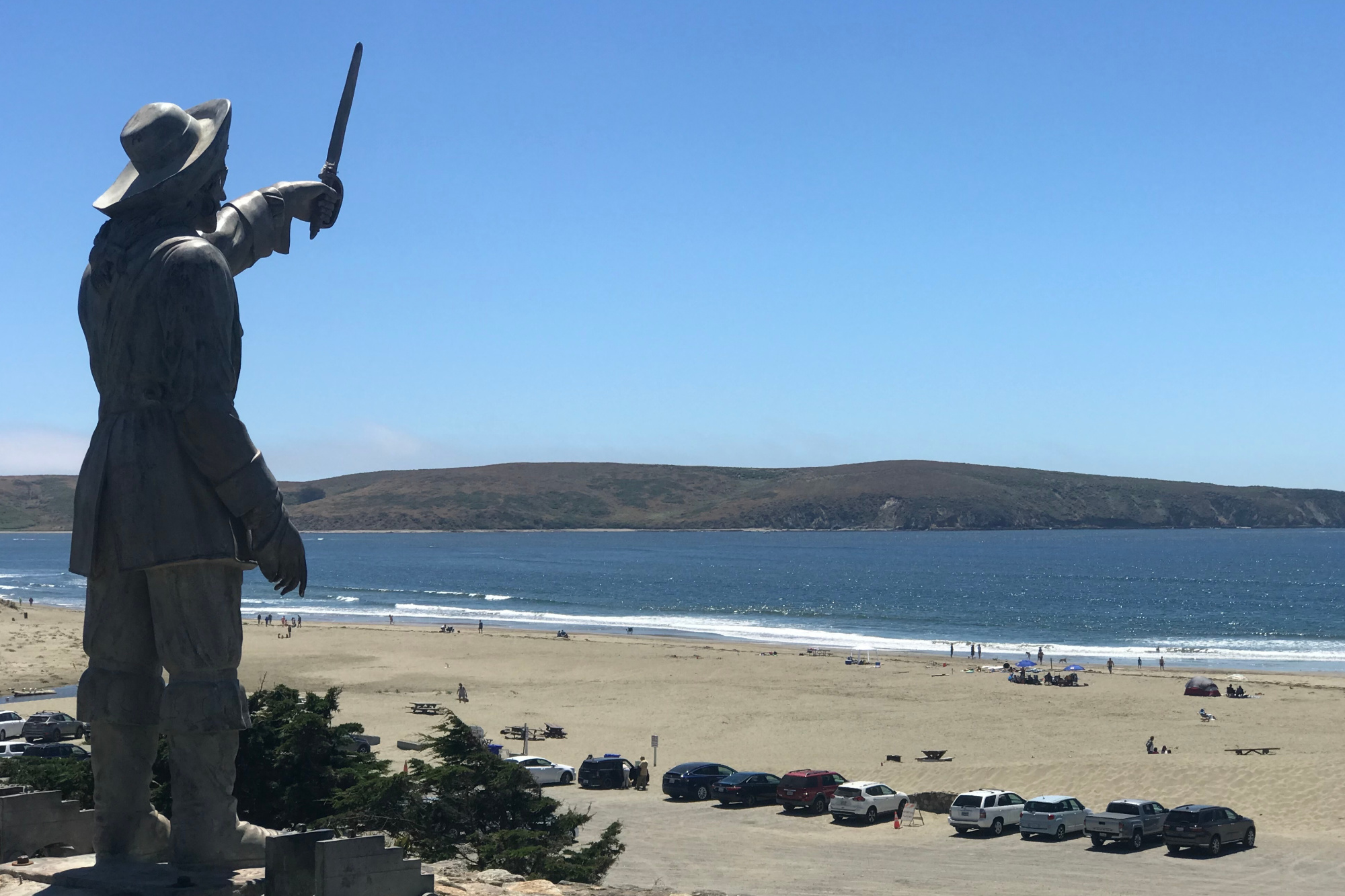 A statue raising a sword over a view of the bay.