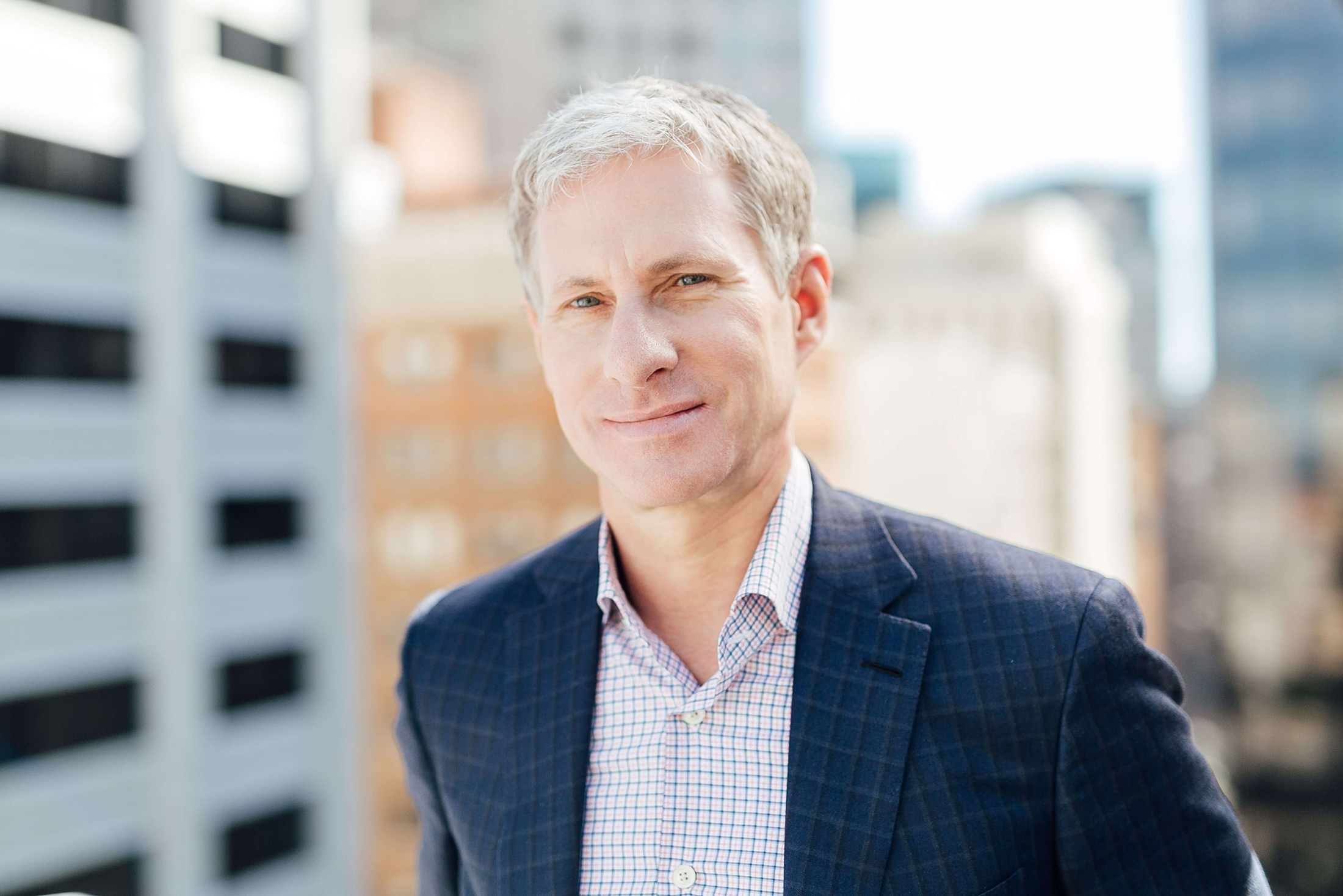 Chris Larsen, chairman of Ripple Labs, poses in a blue blazer at a Downtown location.
