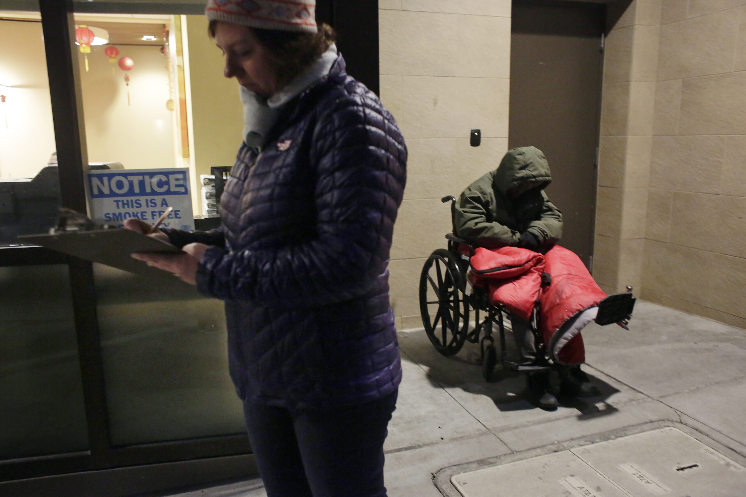 A person with a clipboard conducting the homeless point-in-time count.