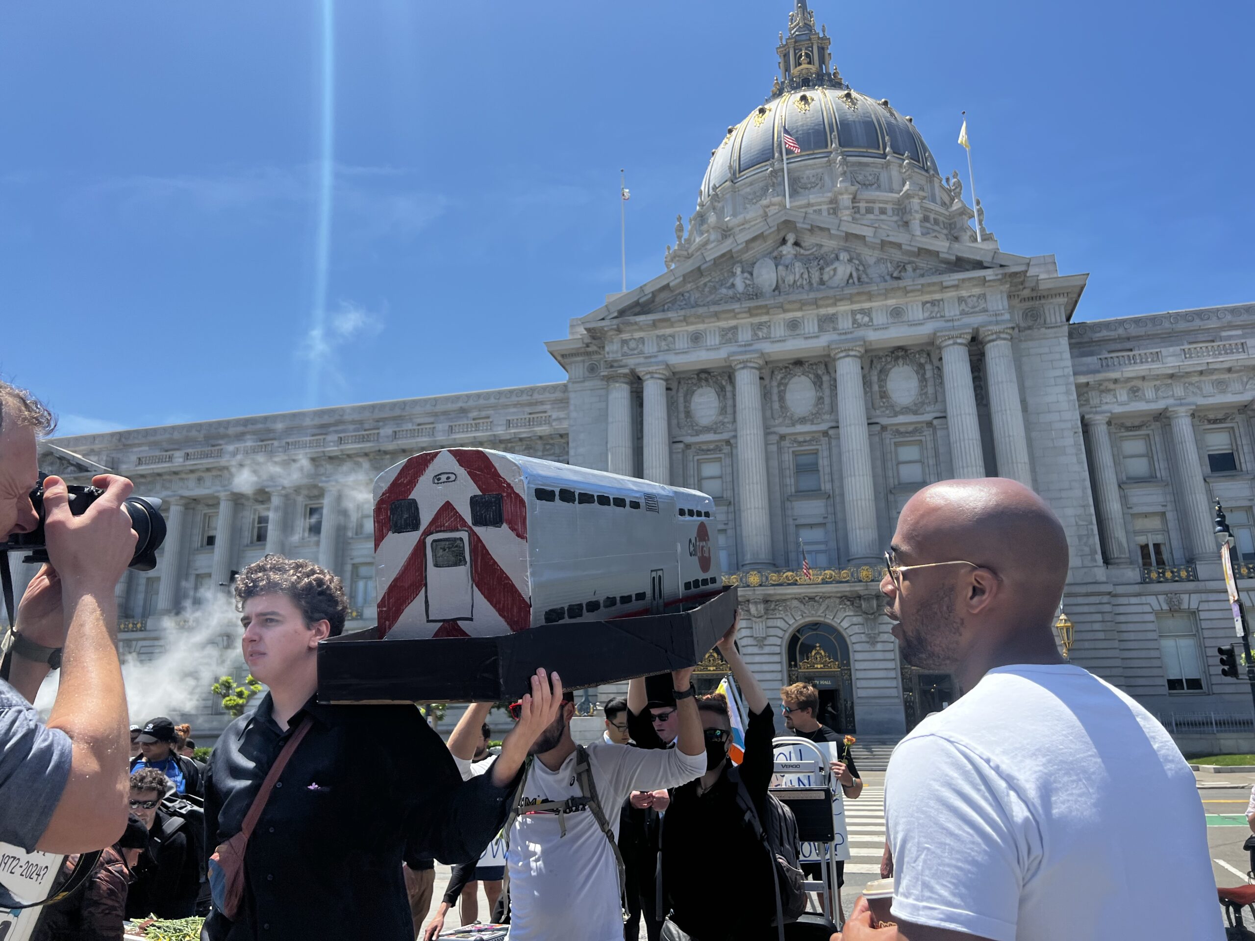 Transit Activists Carry  BART, Muni ‘Trains’ in Caskets to San Francisco City Hall