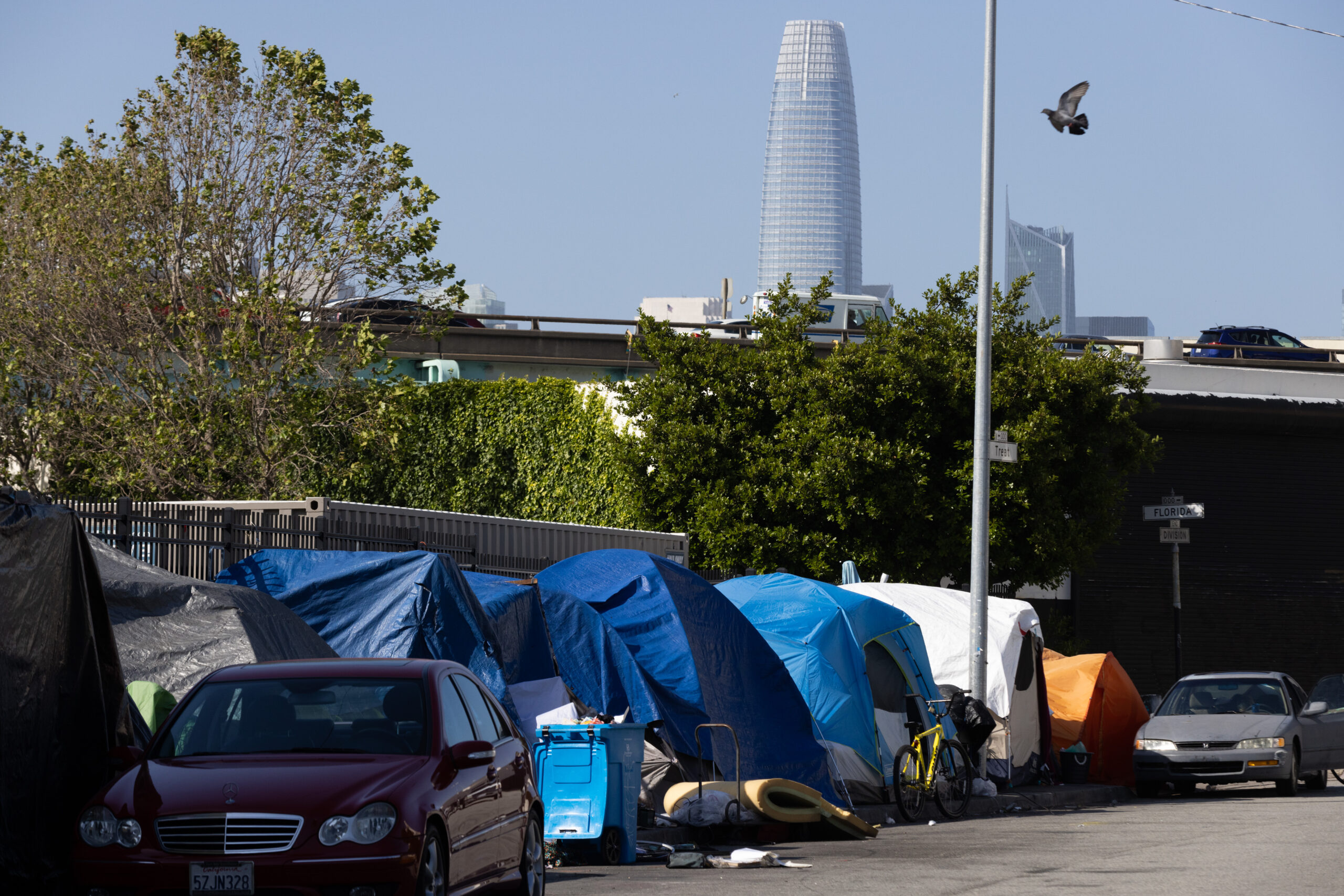 A homeless tent encampment on Division Street at Florida Street with Salesforce Tower in the skyline in San Francisco, on Thursday, June 1, 2023. The homeless crisis in the Bay Area continues and local residents aren’t sure when and if they should be given money to those asking for it. | Benjamin Fanjoy for The Standard