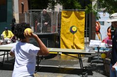 A person is about to throw a ball at a dunk tank target to dunk someone seated inside.