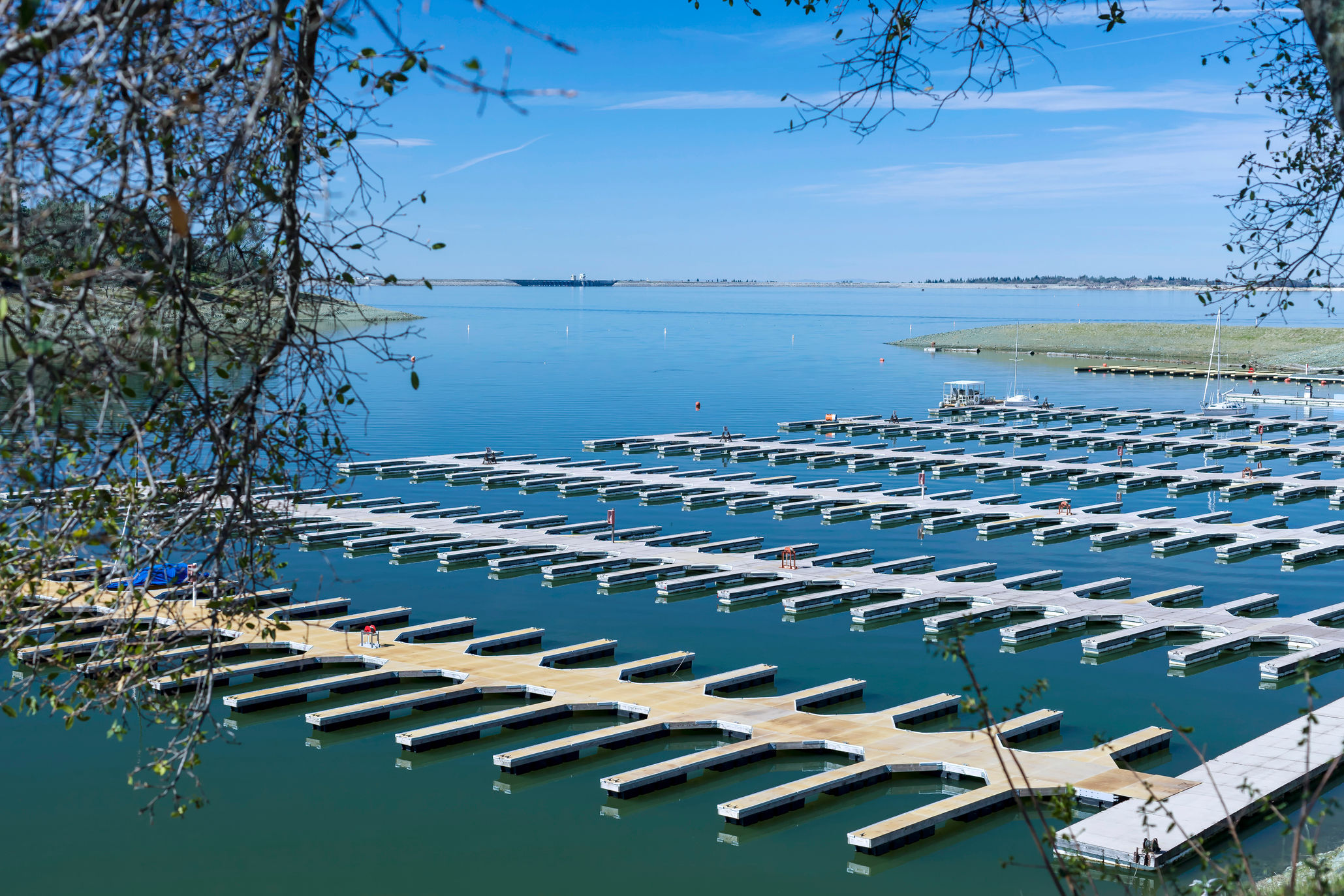 Six rows of empty docks on a calm lake.