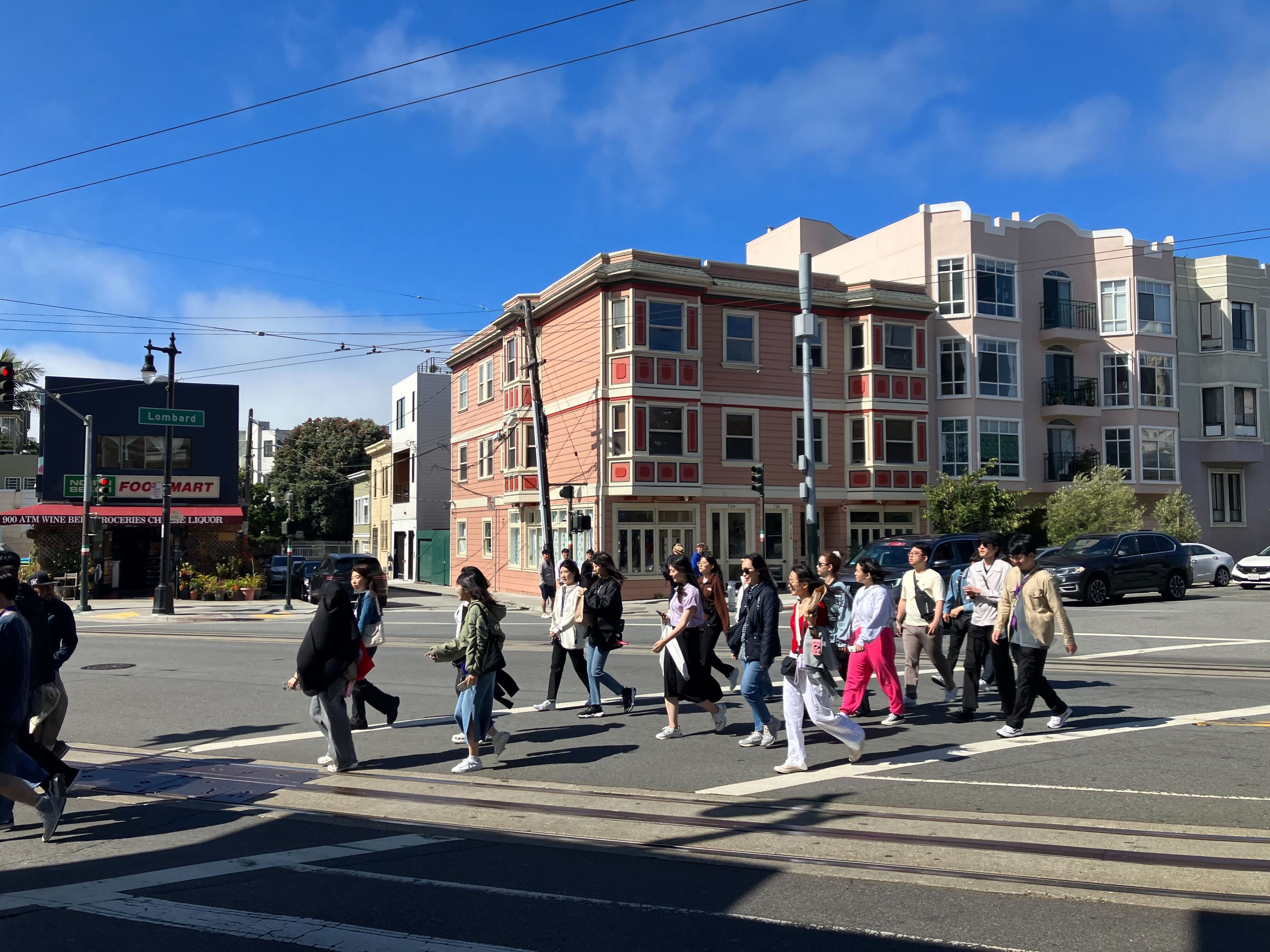 A group of people crossing the street at Columbus Avenue in North Beach, San Francisco.