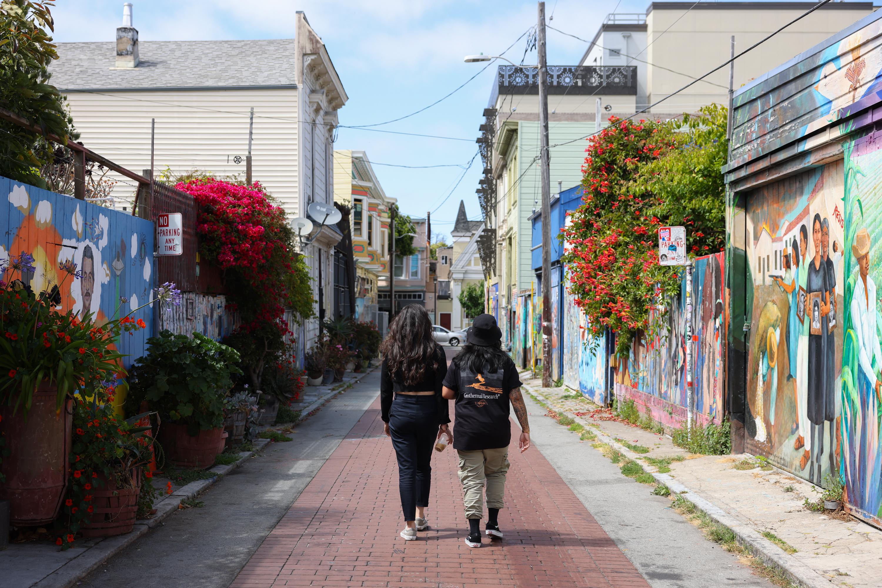 Two people are walking down Balmy Alley