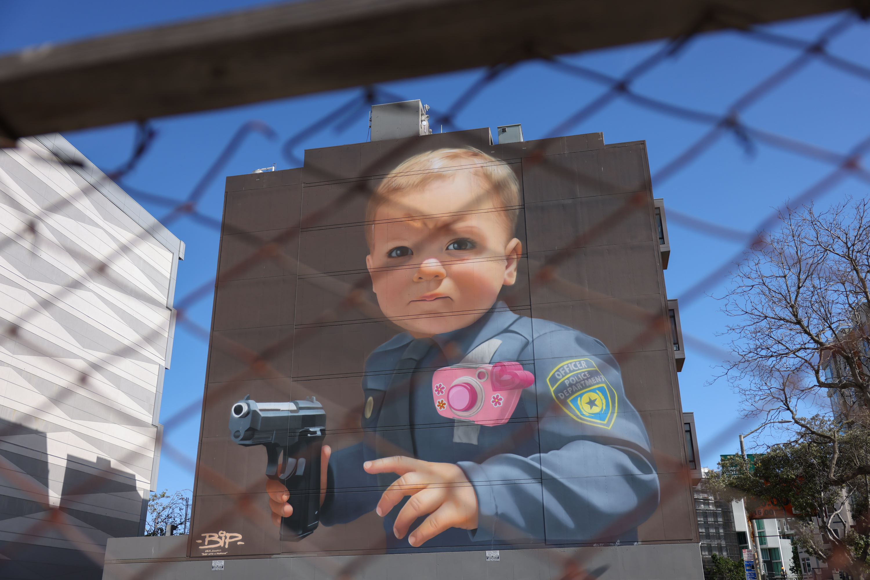 Large painting of a baby cop on the side of a building