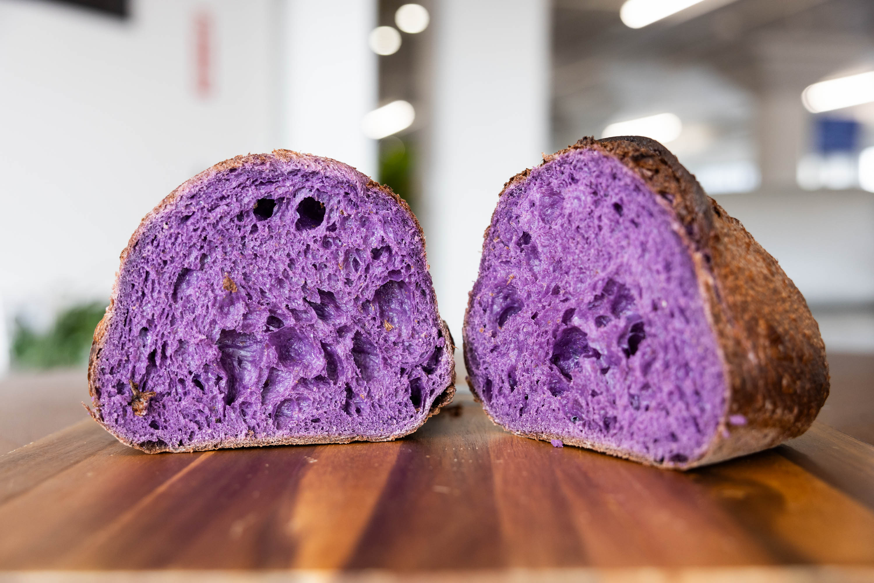 A loaf of bread sliced half has purple insides.