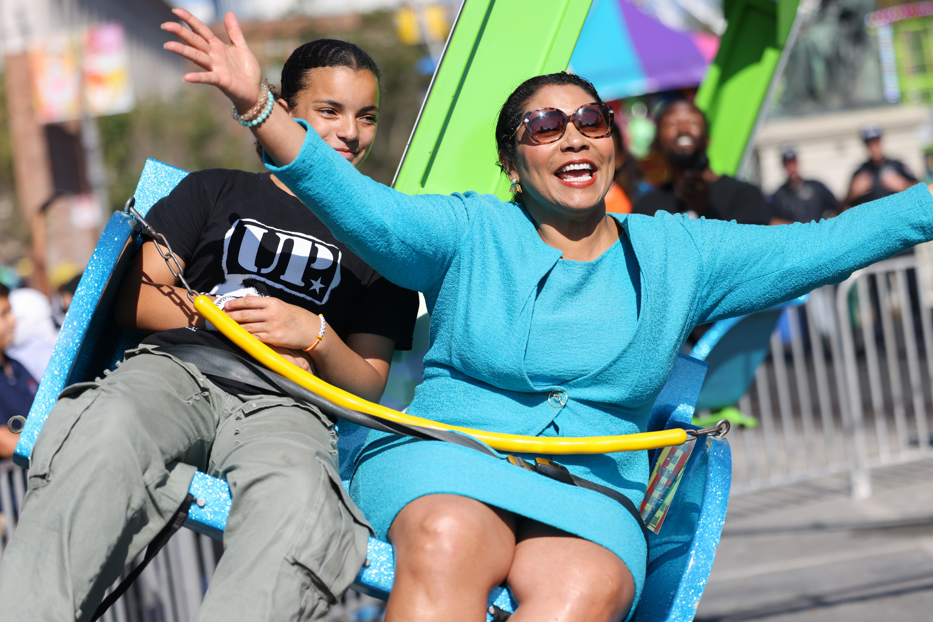 Woman in blue enjoys a carnival ride.