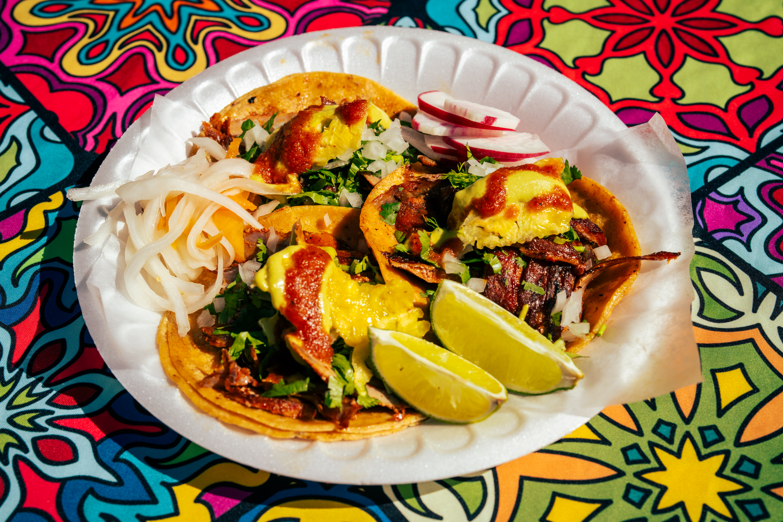 A plate of El Charro's signature al pastor tacos features perfectly marinated and thinly cut pork served to order for hungry customers at the curbside food stand.