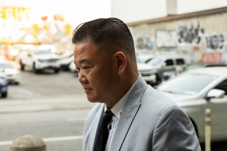 Ken Hong Wong, wearing a grey suit, walks into the federal courthouse looking downward.