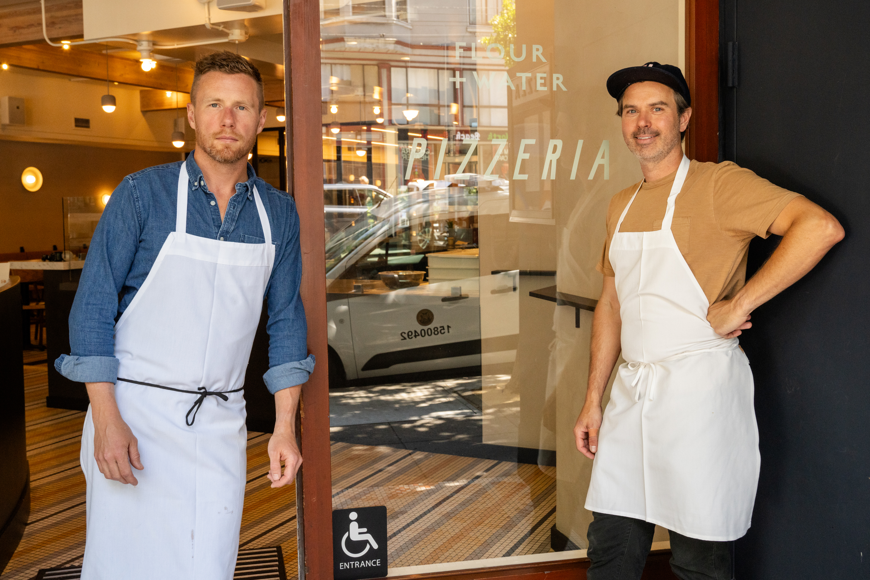 Thomas McNaughton, left, and Ryan Pollnow, right, of Flour + Water Pizzeria pose for a portrait outside their new restaurant in San Francisco on Aug. 10, 2023.