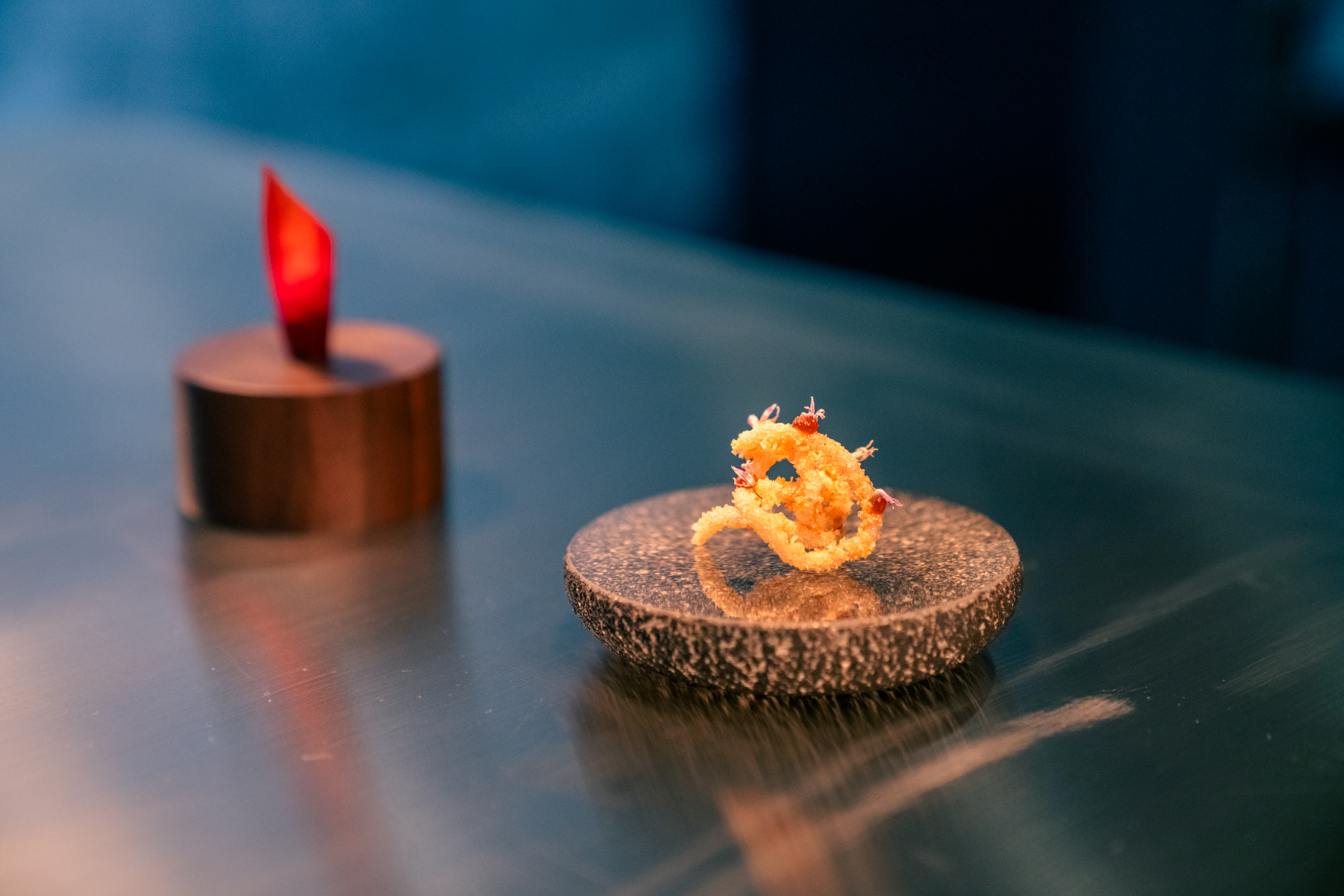 An item from the tasting menu offers a crispy fried chip made from sweet potato noodles and beef tendon dusted in caramelized onion powder.
