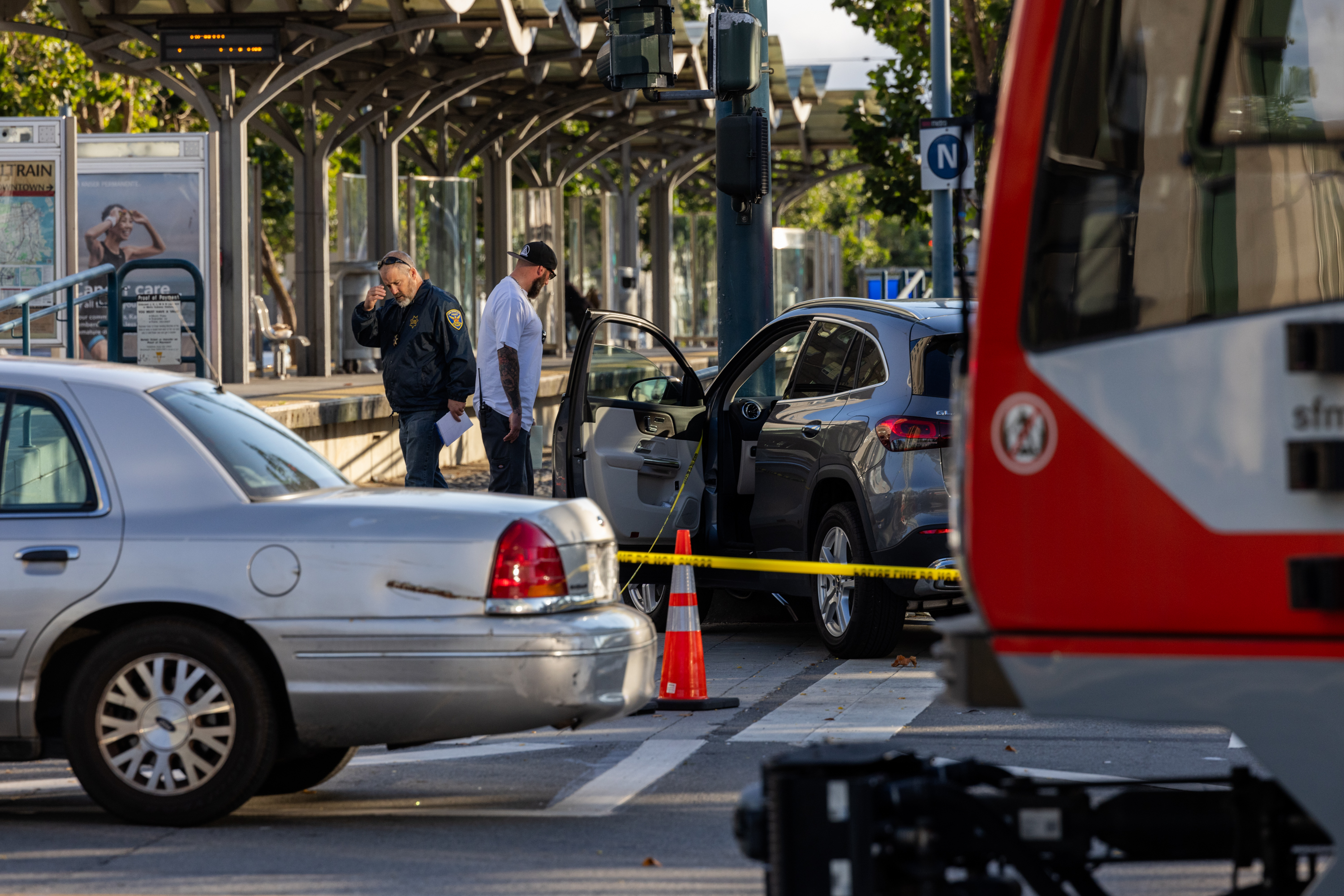 A car crash scene on a city street with police, vehicles, and caution tape.