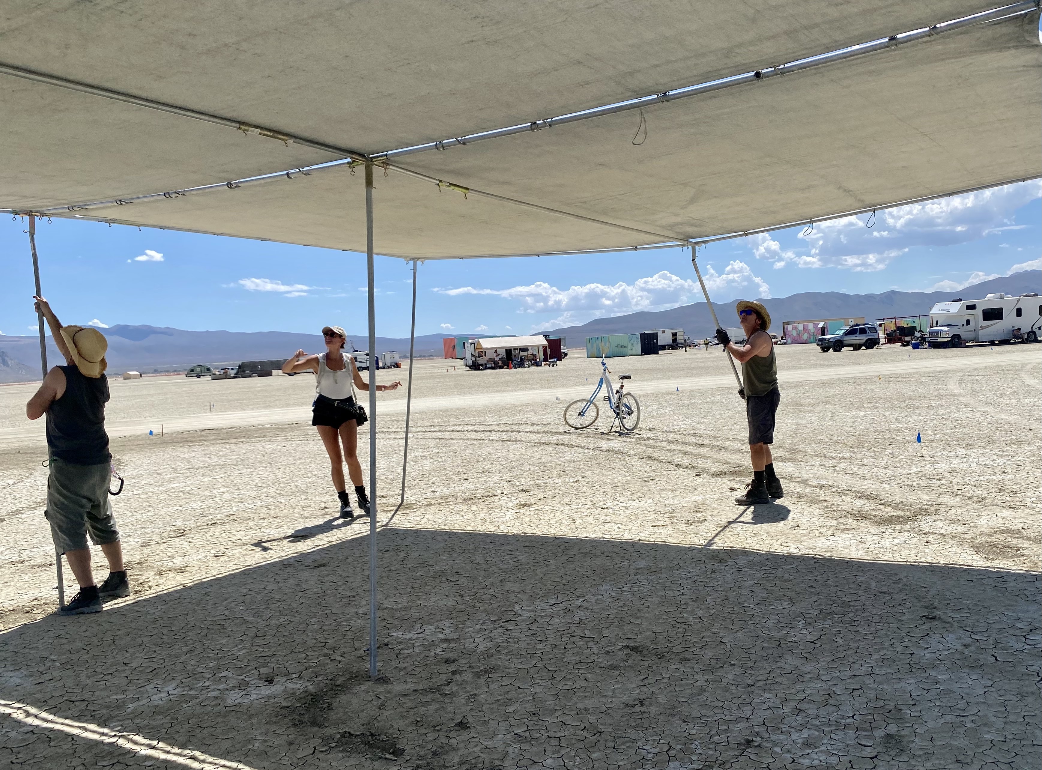 Burning Man 2023 participants set up a shade structure in the Nevada desert.