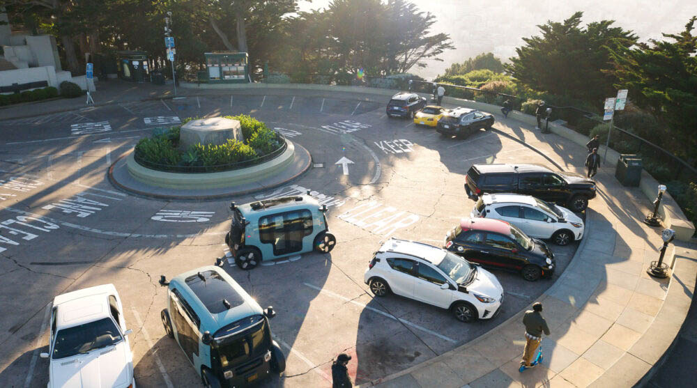 A Zoox car rides around a Coit Tower parking lot in San Francisco.