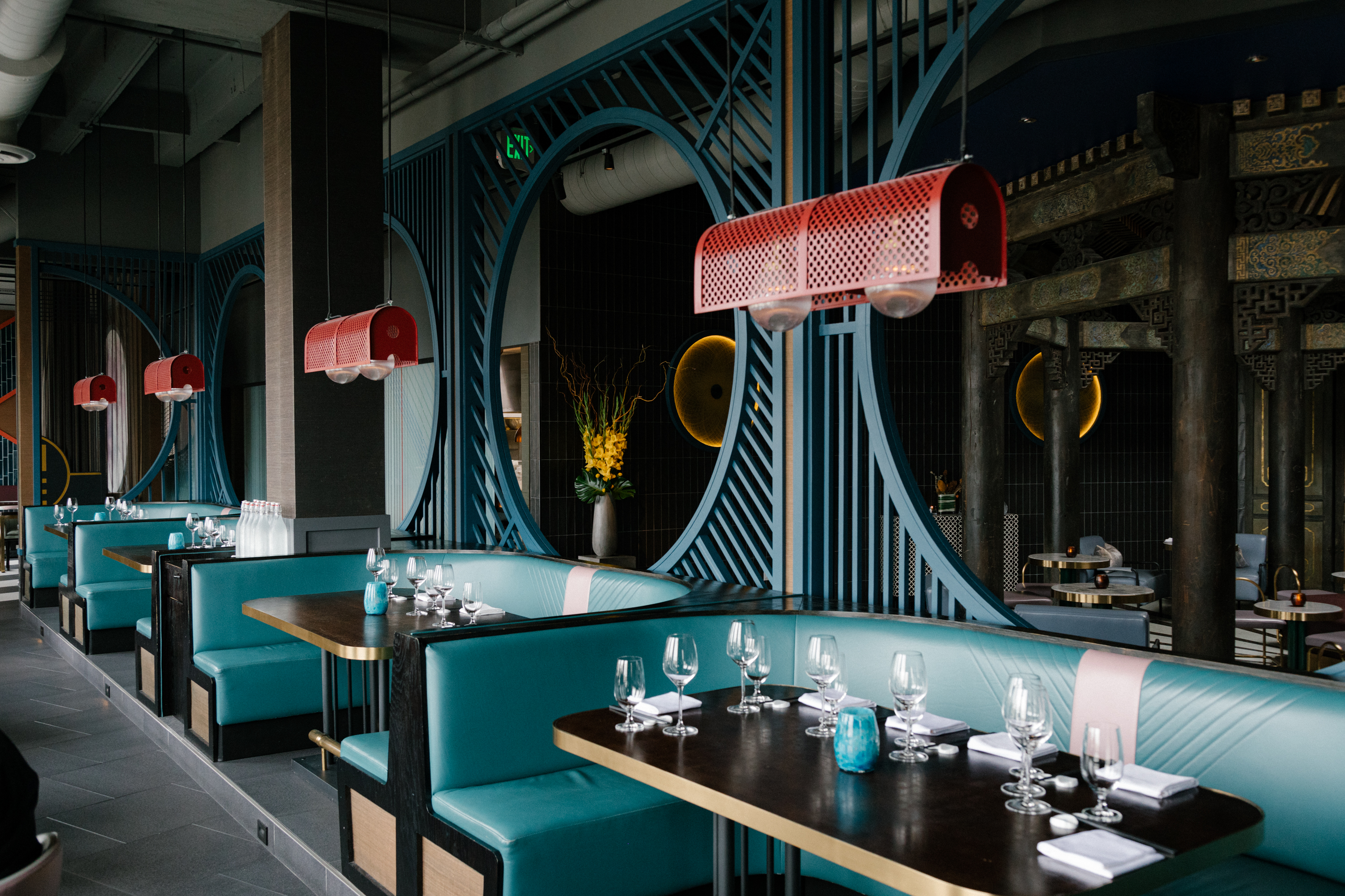 Turquoise booths stand in an elegant Chinese restaurant.