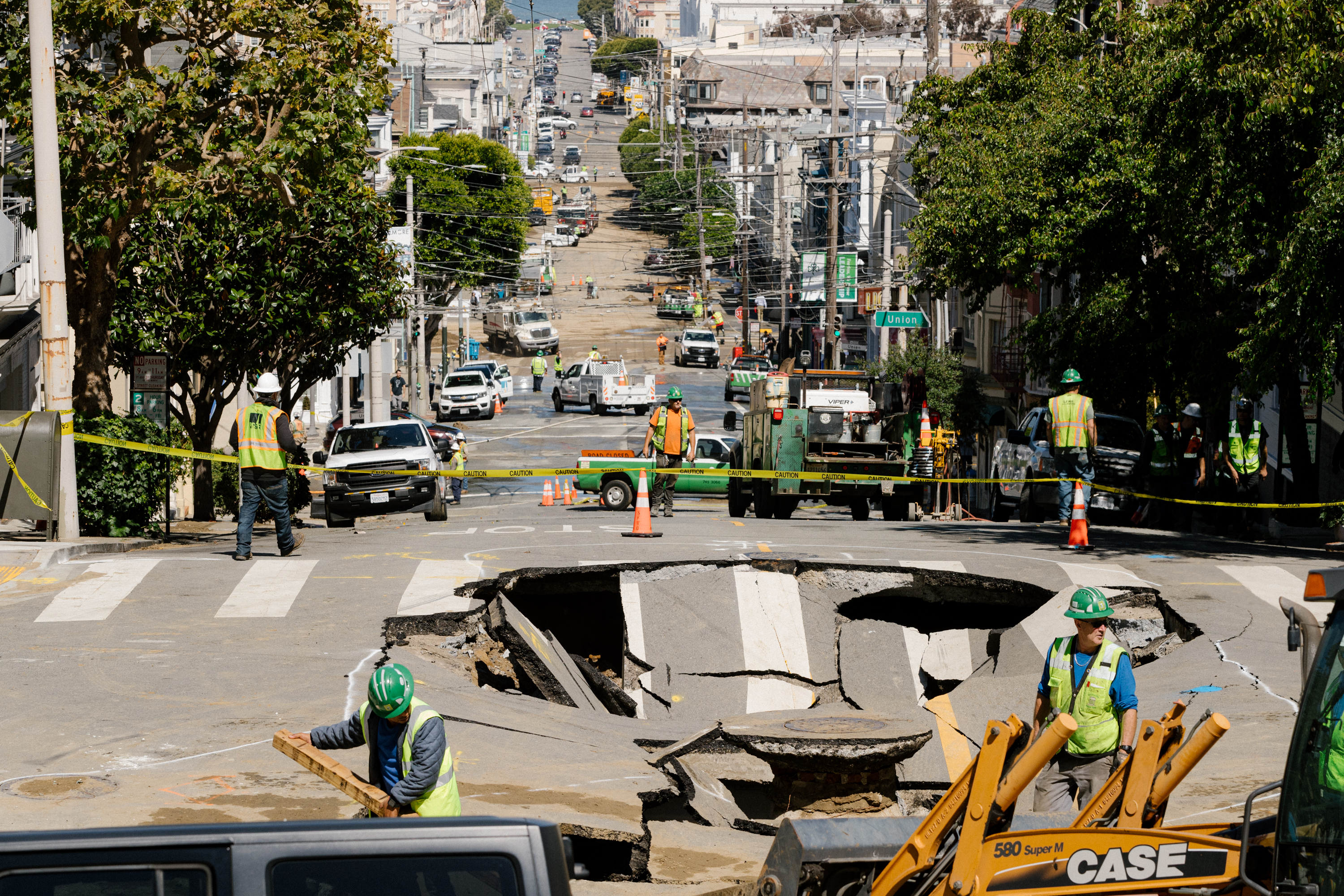 Utility workers on the scene of a sinkhole in the intersection of Fillmore and Green streets and subsequent flooding that affected areas down the hill toward Lombard Street in San Francisco on Monday, September 11, 2023.