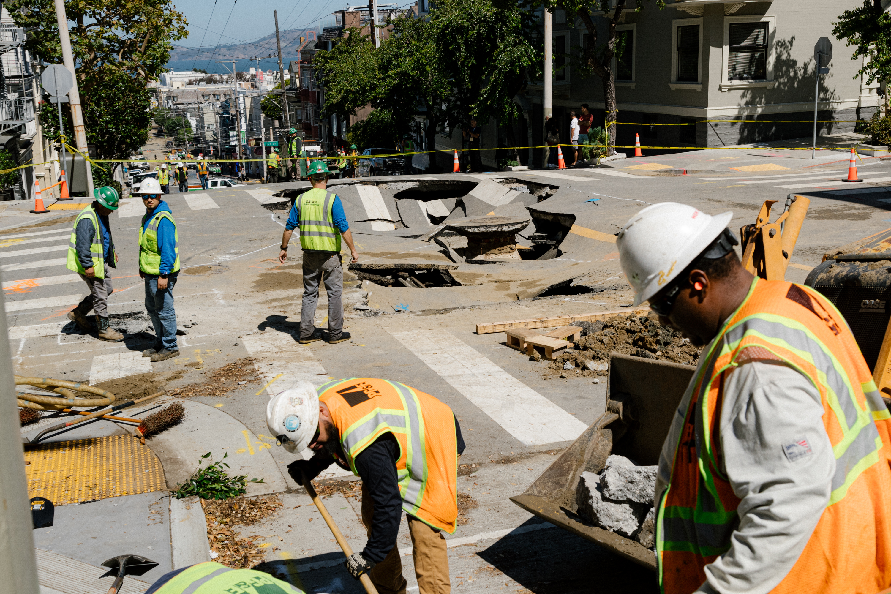 Utility workers on the scene of a sinkhole in the intersection of Fillmore and Green streets and subsequent flooding that affected areas down the hill toward Lombard Street in San Francisco on Monday, September 11, 2023.