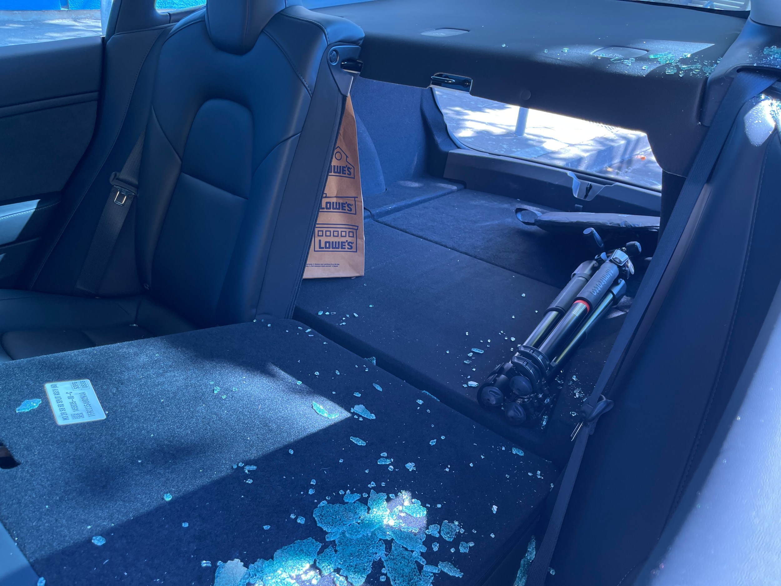 Broken glass litters the inside of a rented and broken-into 2023 Tesla Model S on Broadway near 24th Street in Oakland last Saturday.