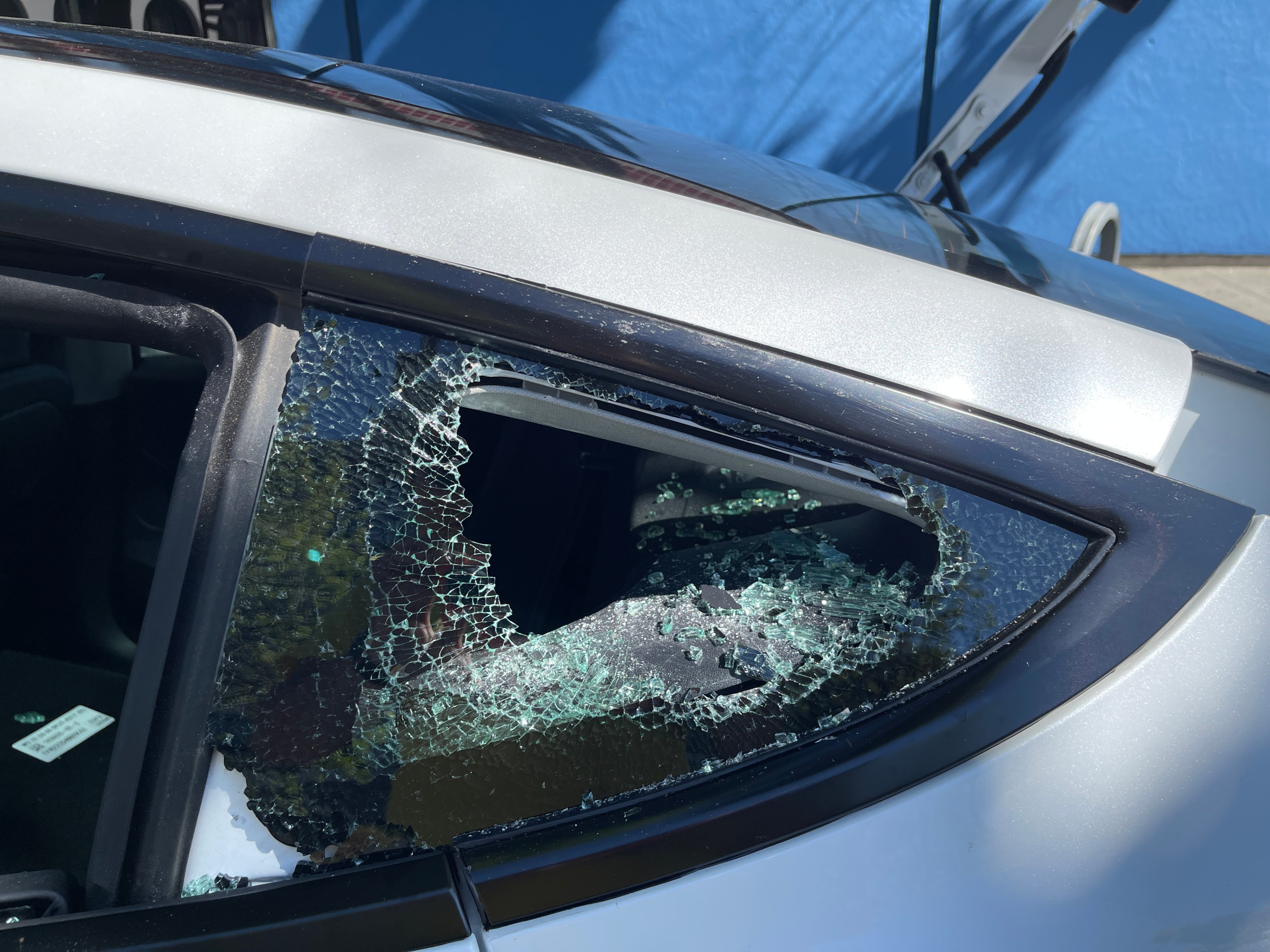 Broken glass glints within a &quot;bipped&quot; rear driver-side window of a rented 2023 Tesla Model S on Broadway near 24th Street in Oakland last Saturday.