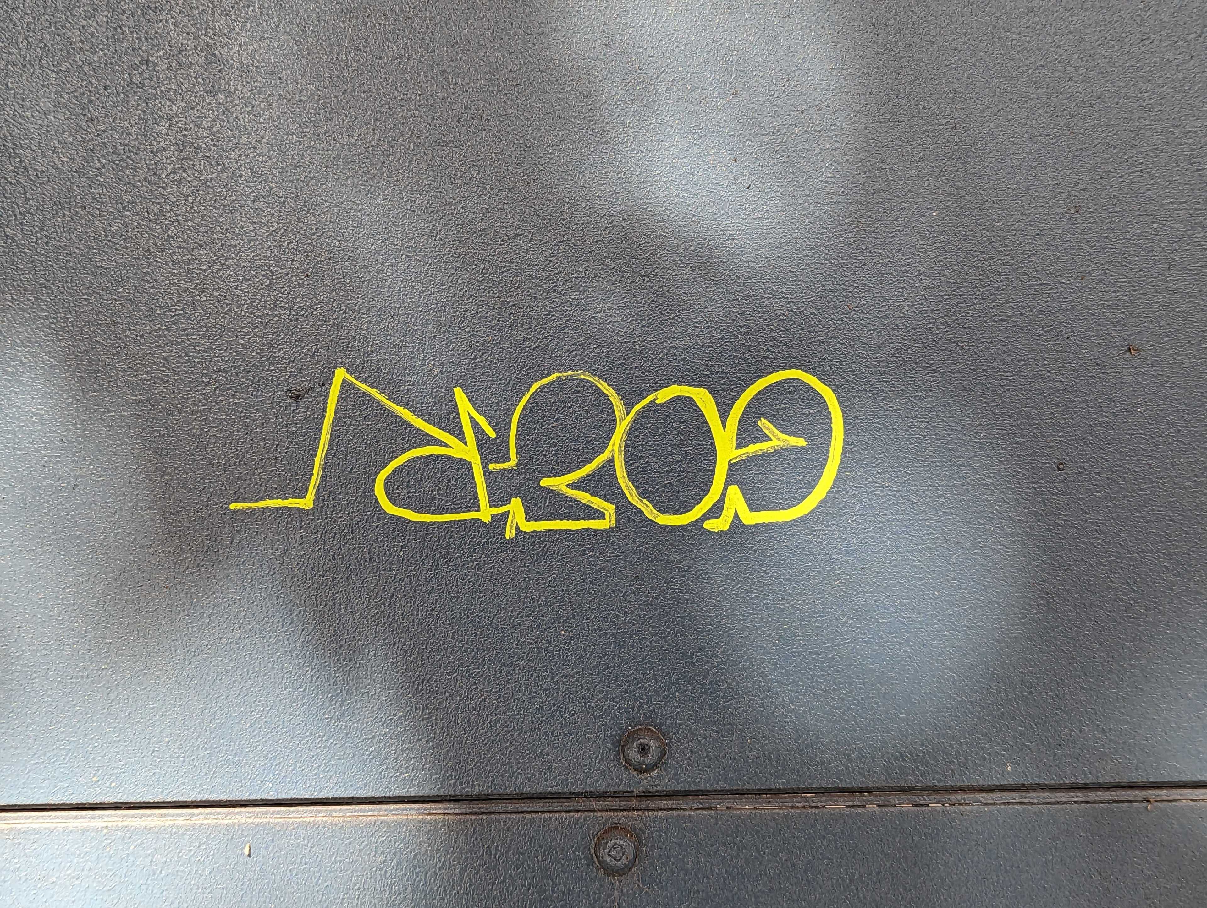 Outside a popular wine bar on Folsom Street in San Francisco's South of Market neighborhood, a small yellow markered graffiti tag mars a doorway.