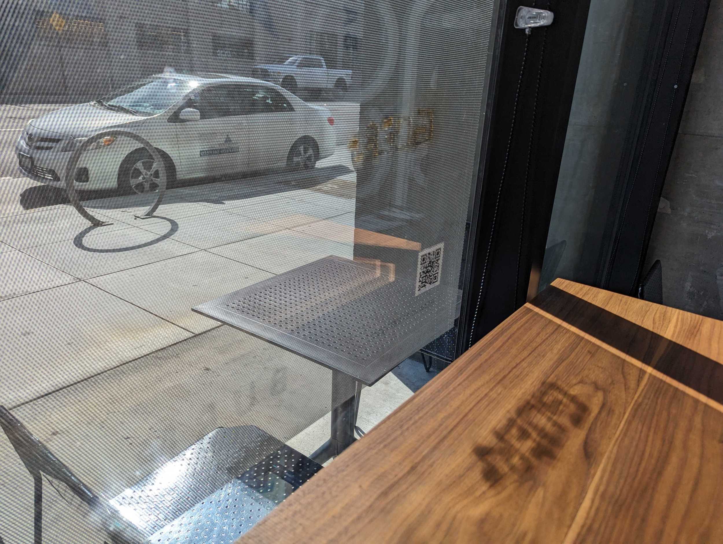Inside the Bay of Burma restaurant on Folsom Street in San Francisco's South of Market neighborhood, midday sunlight sends the shadow of a tag singed into a front window's sticker late last month onto a wooden countertop inside.