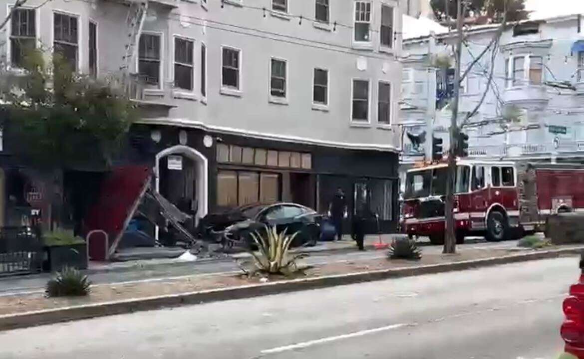 An image on the Citizen news platform Tuesday shows a Tesla on a Divisadero Street sidewalk shortly after a crash into a Muni bus stop.