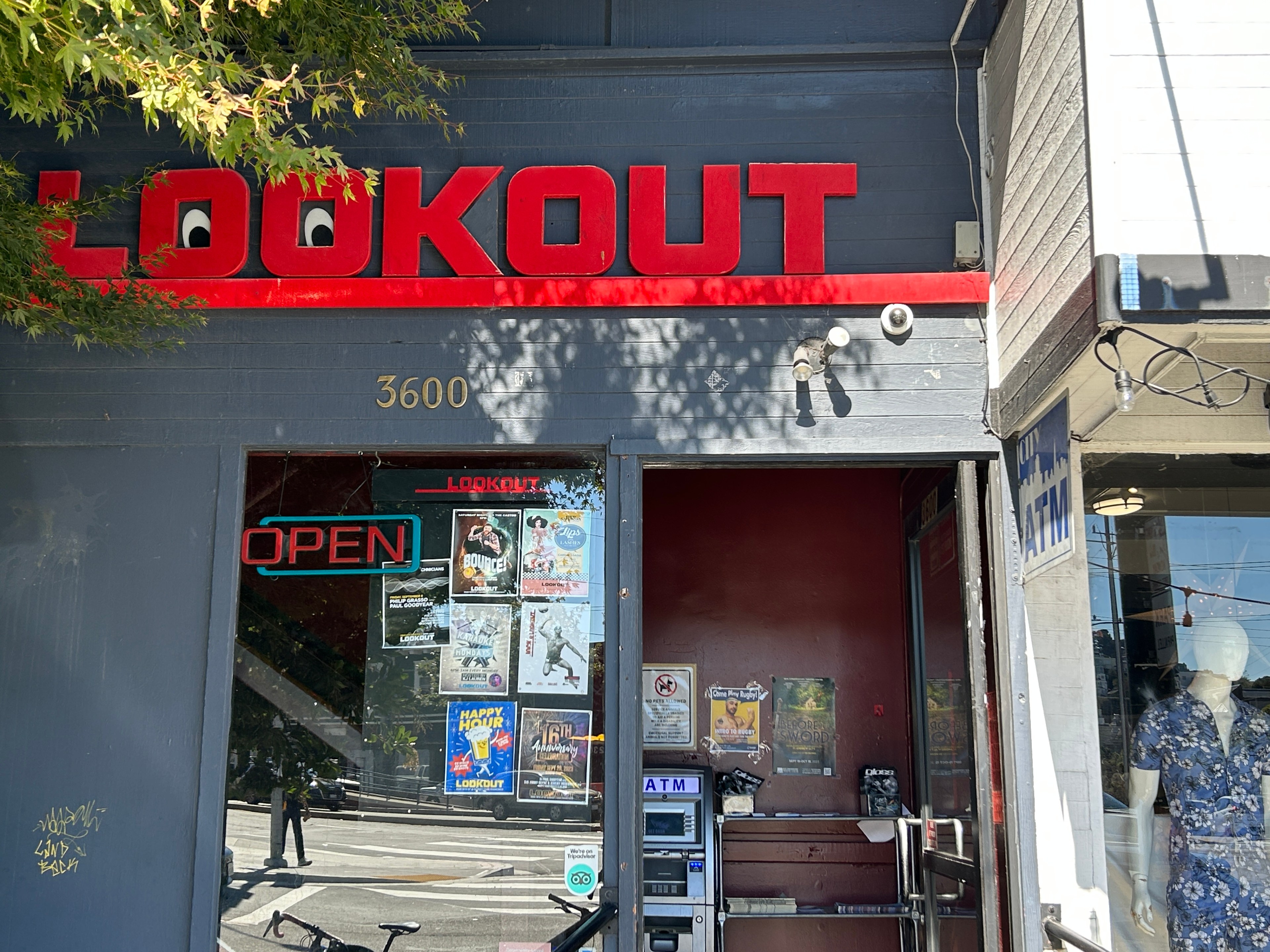 Bright red sign says LOOKOUT on building storefront