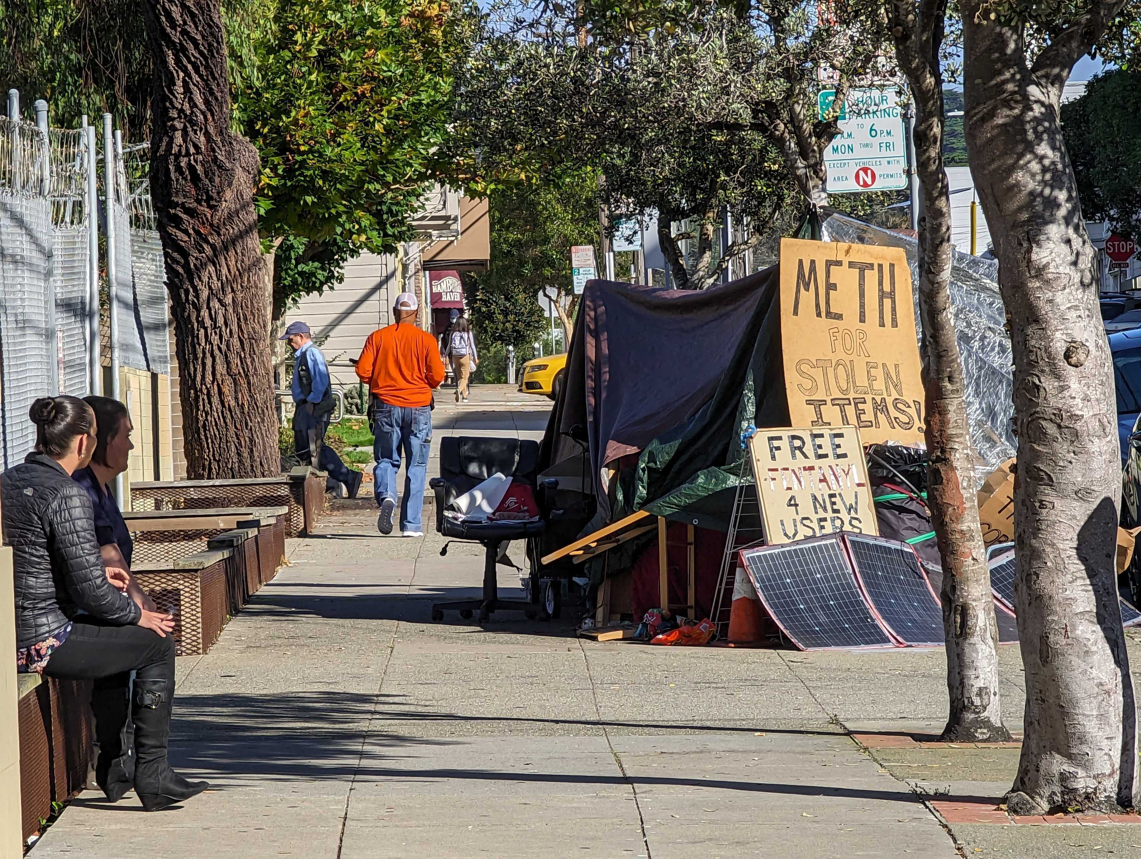 Signs reading &quot;Meth for stolen items&quot; and &quot;free fentanyl for new users&quot; sit atop Joseph Adam Moore's encampment on Ninth Avenue north of Geary Boulevard in San Francisco's Inner Richmond neighborhood.