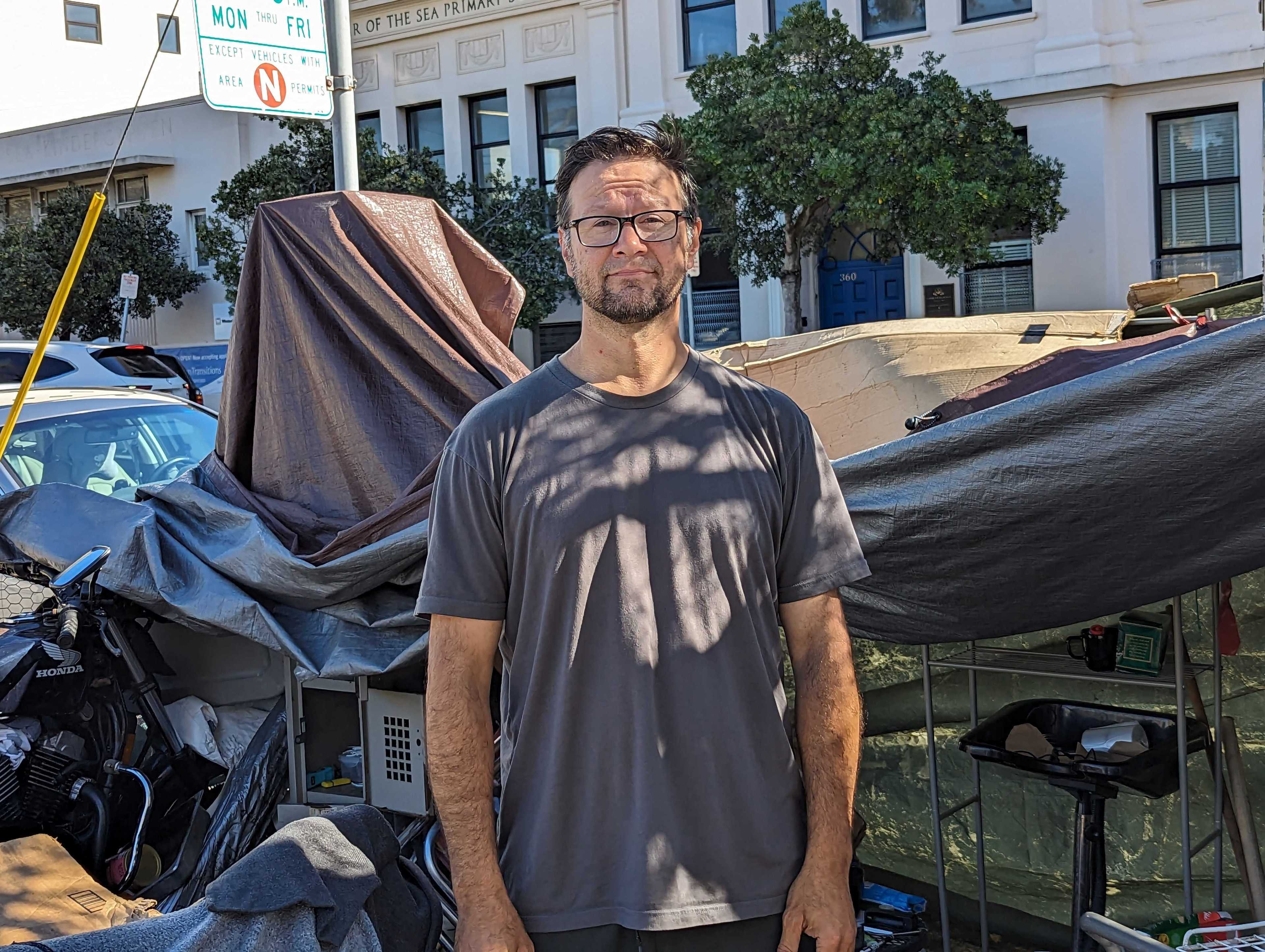 Joseph Adam Moore stands next to his encampment on Ninth Avenue north of Geary Boulevard in San Francisco's Inner Richmond neighborhood.