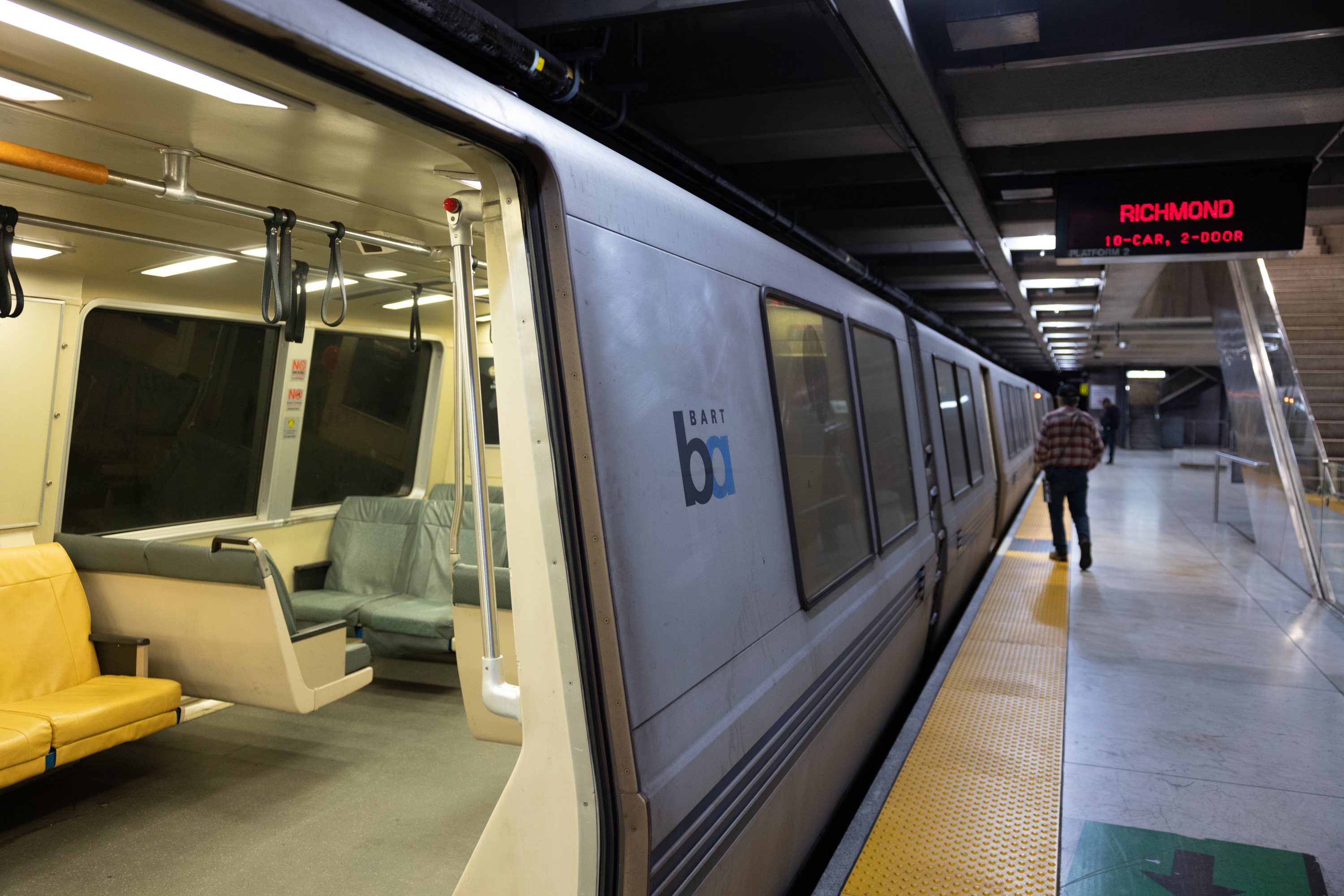 A BART train with an open door at an underground station.