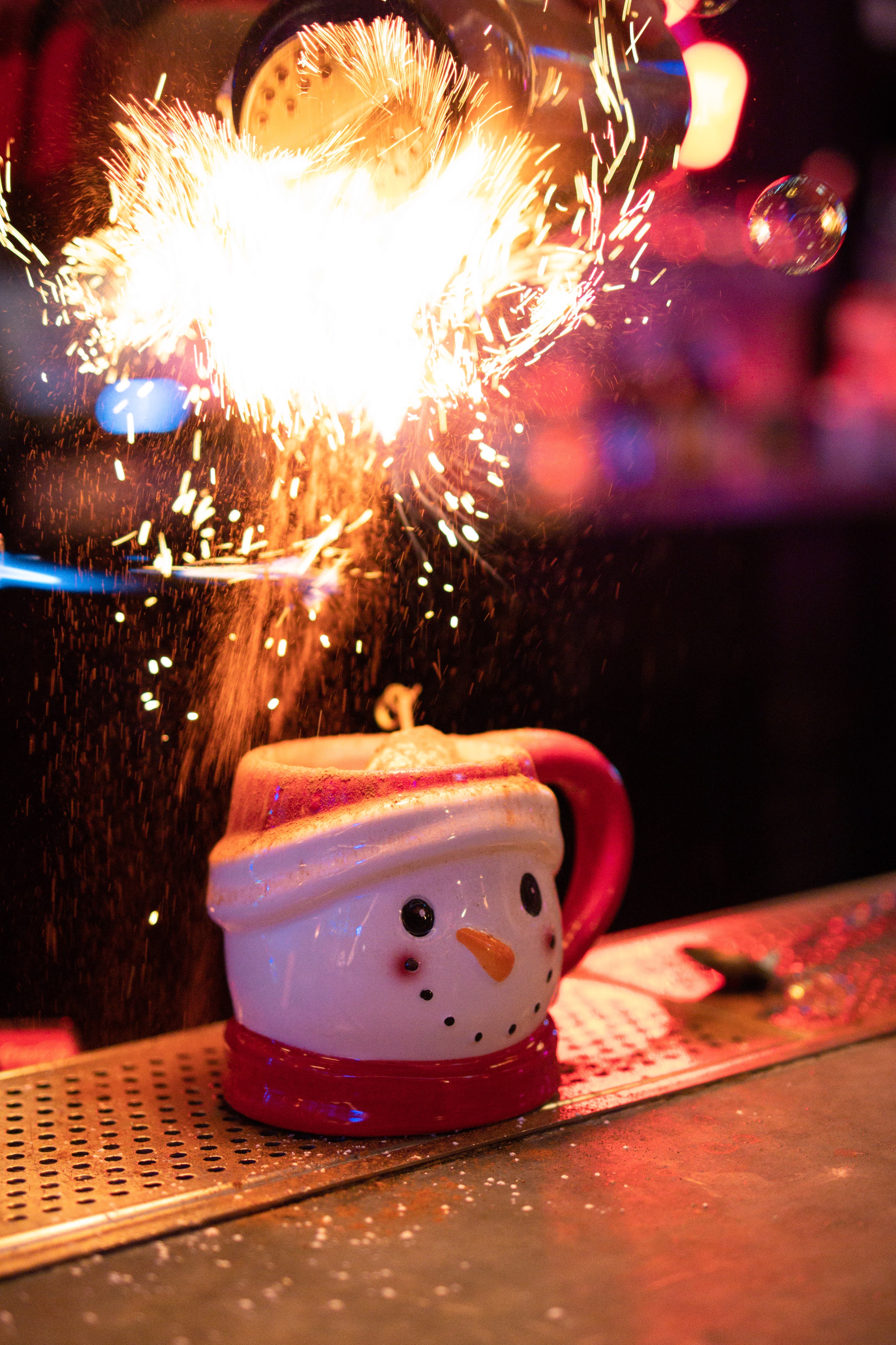 A spark of fire lights up a snowman mug. 