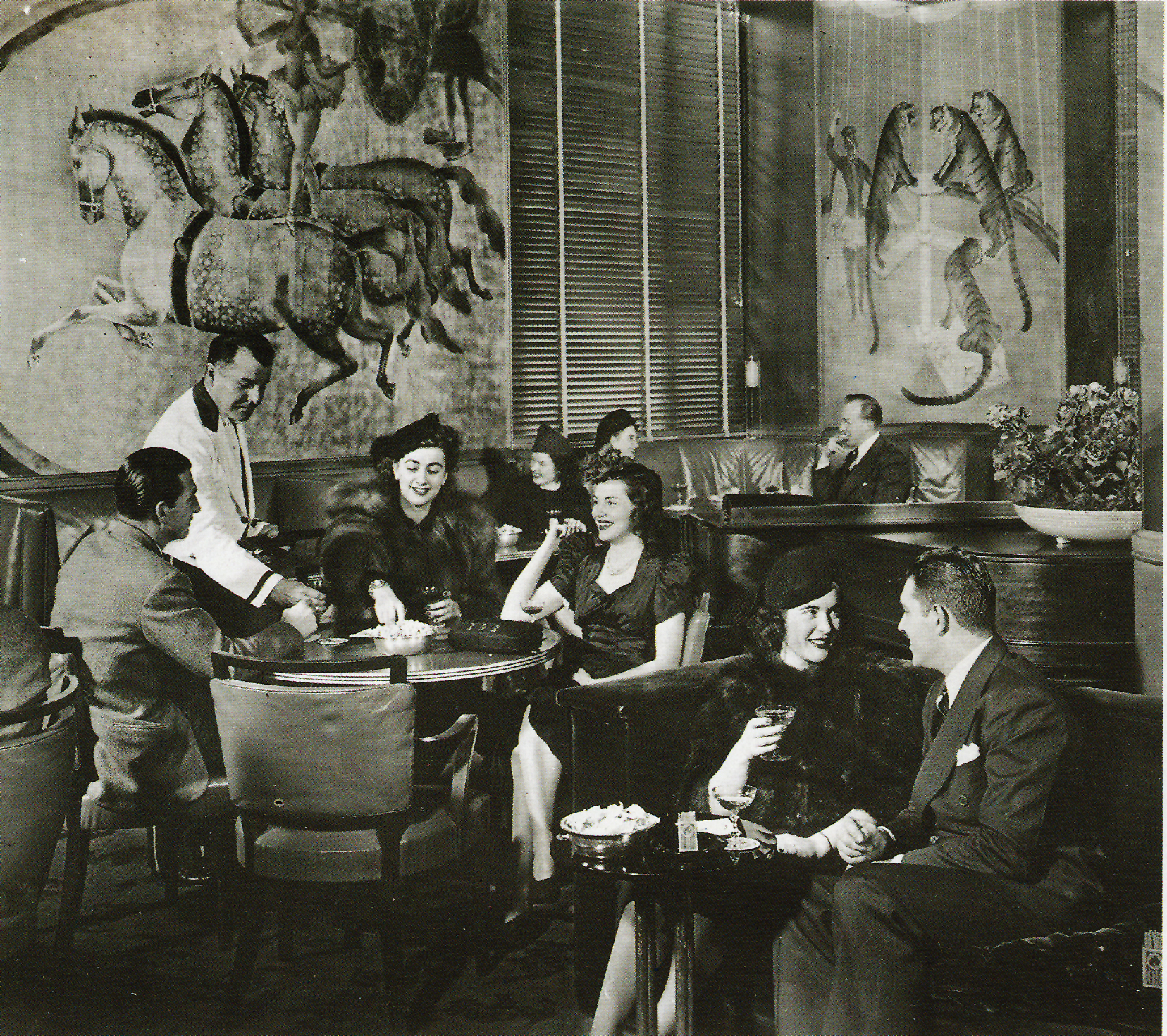 People lounging in a ornate room while drinking cocktails.