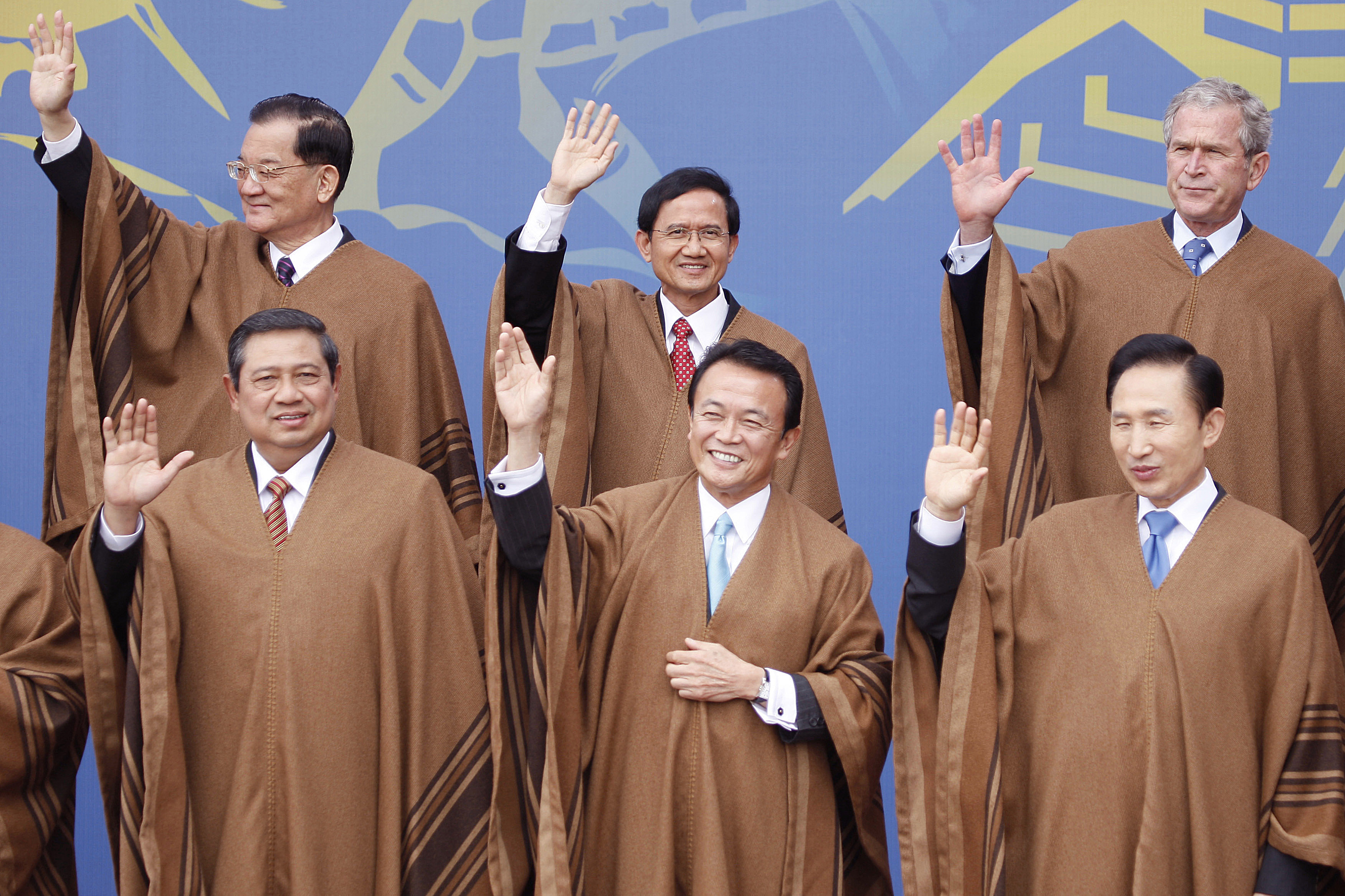 World leaders are seen waving in a group photo while donning traditional Peruvian attire.