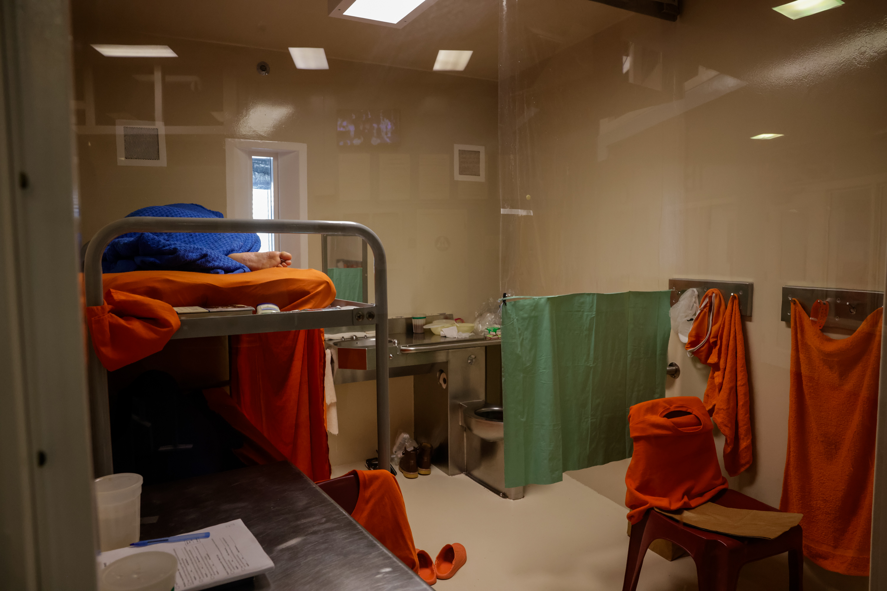 An inmate sleeps inside a jail cell.