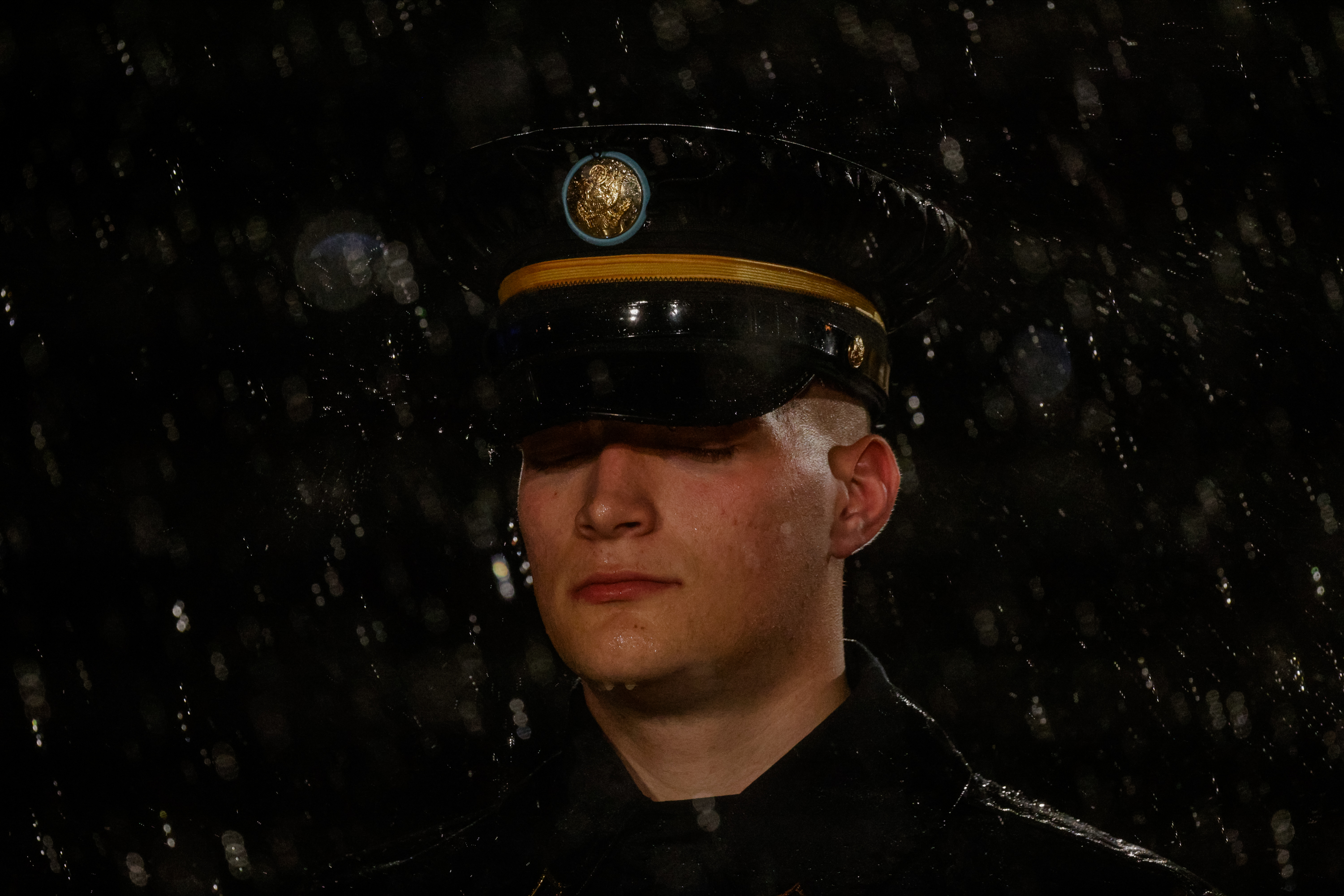 A service member stands in the rain