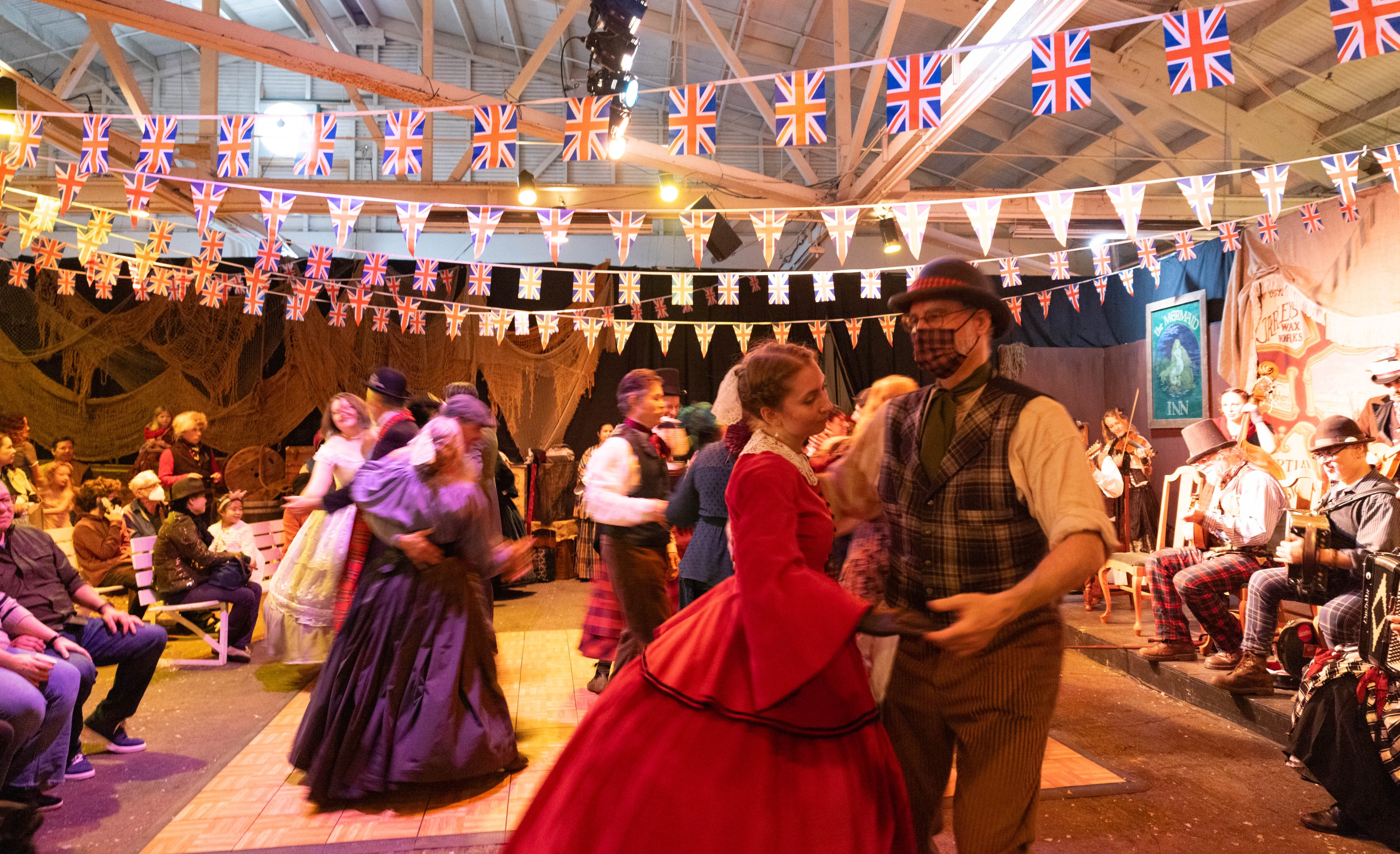Couples dance while clad in Victorian era clothing at the Great Dickens Christmas Fair.